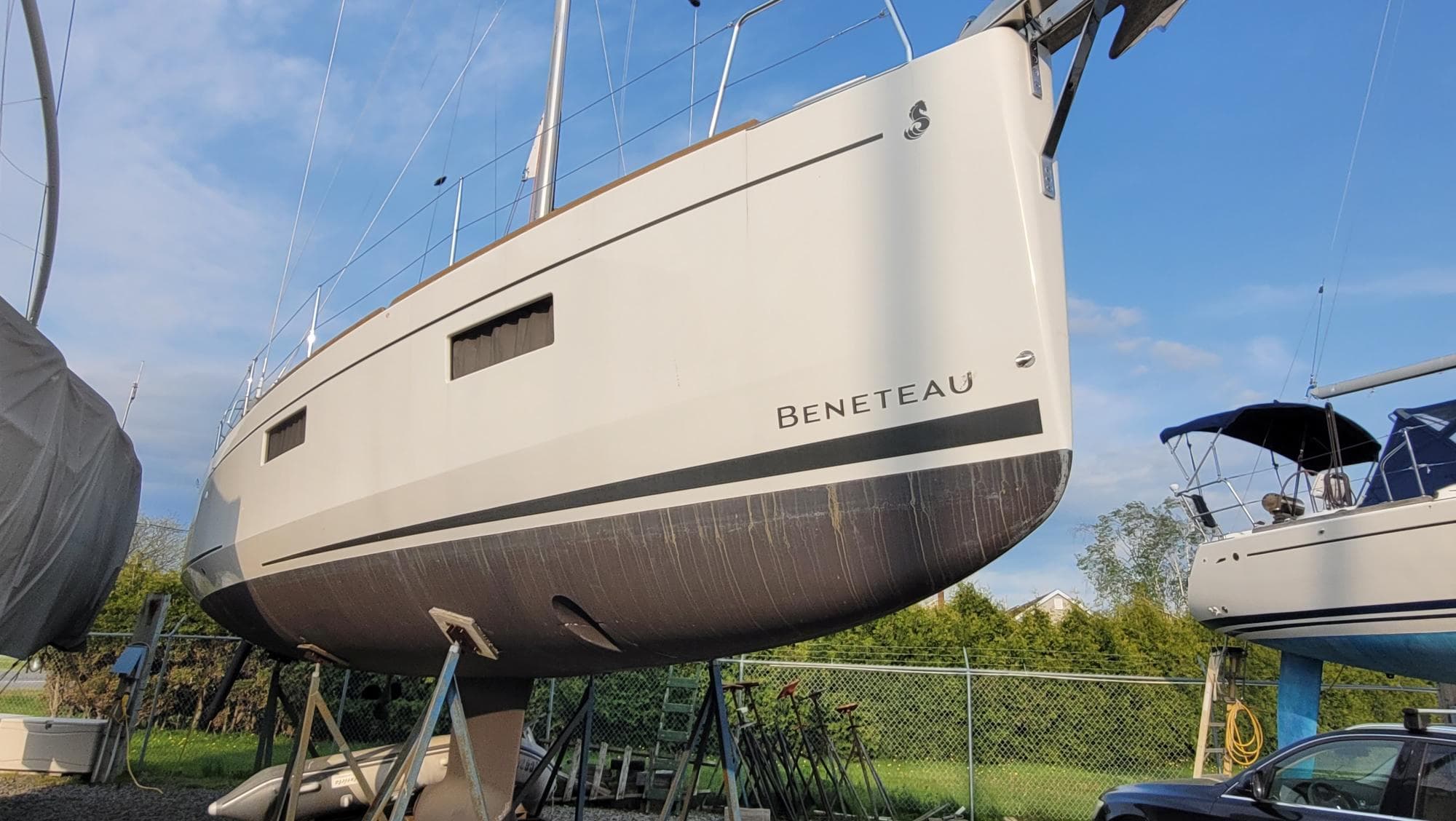 Beneteau Oceanis 38.1 sailboat, 2020 model, on dry dock under clear blue sky.
