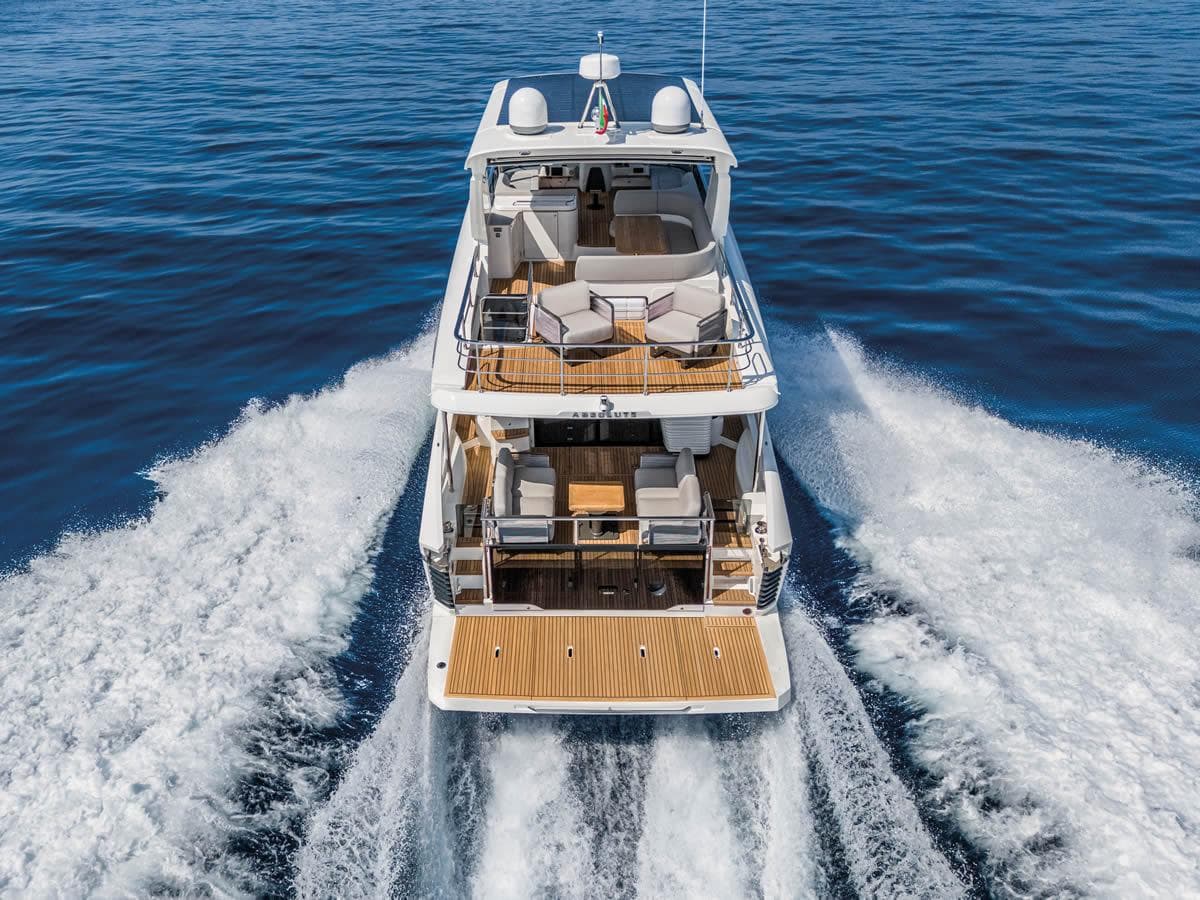 2025 Absolute 53 Navetta yacht cruising on open water, rear view.