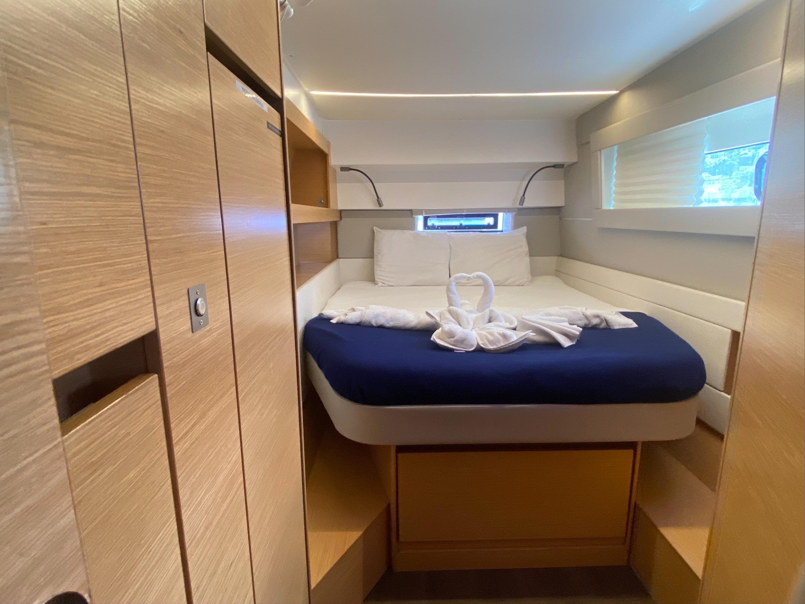 Luxurious cabin interior of 2019 Nautitech 46 Fly catamaran with elegant bedding and wood finishes.