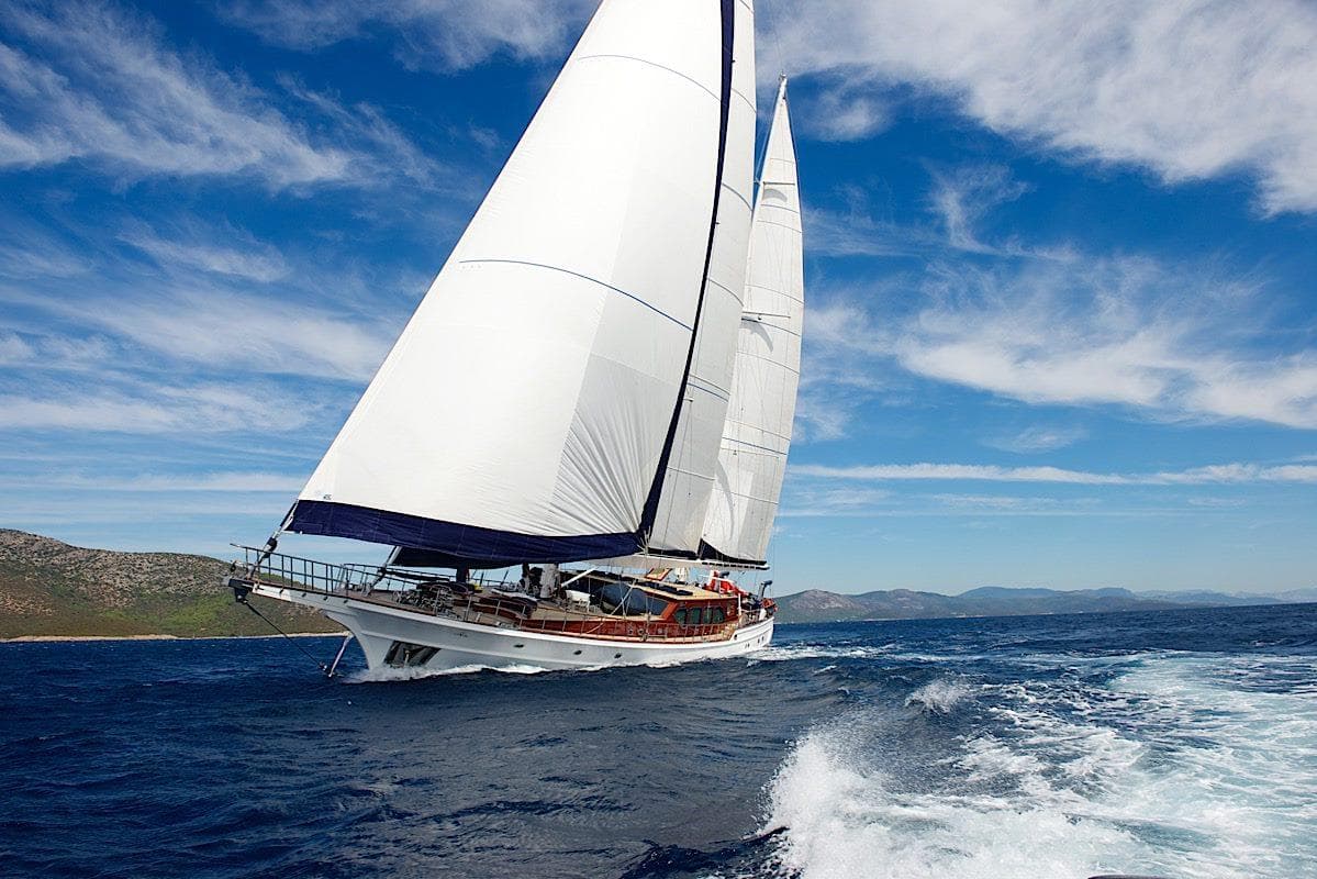 Sailing yacht "Steel Pax Navi 43 m" cruising on open sea under clear blue skies.