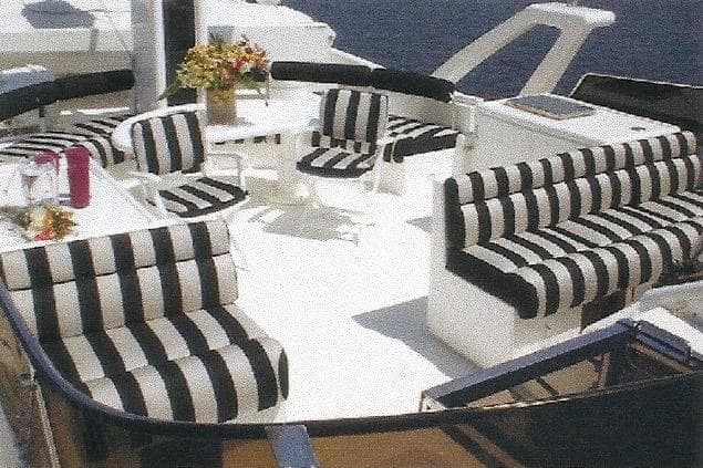 Luxurious Dyna Laguna yacht deck with striped seating and ocean view.