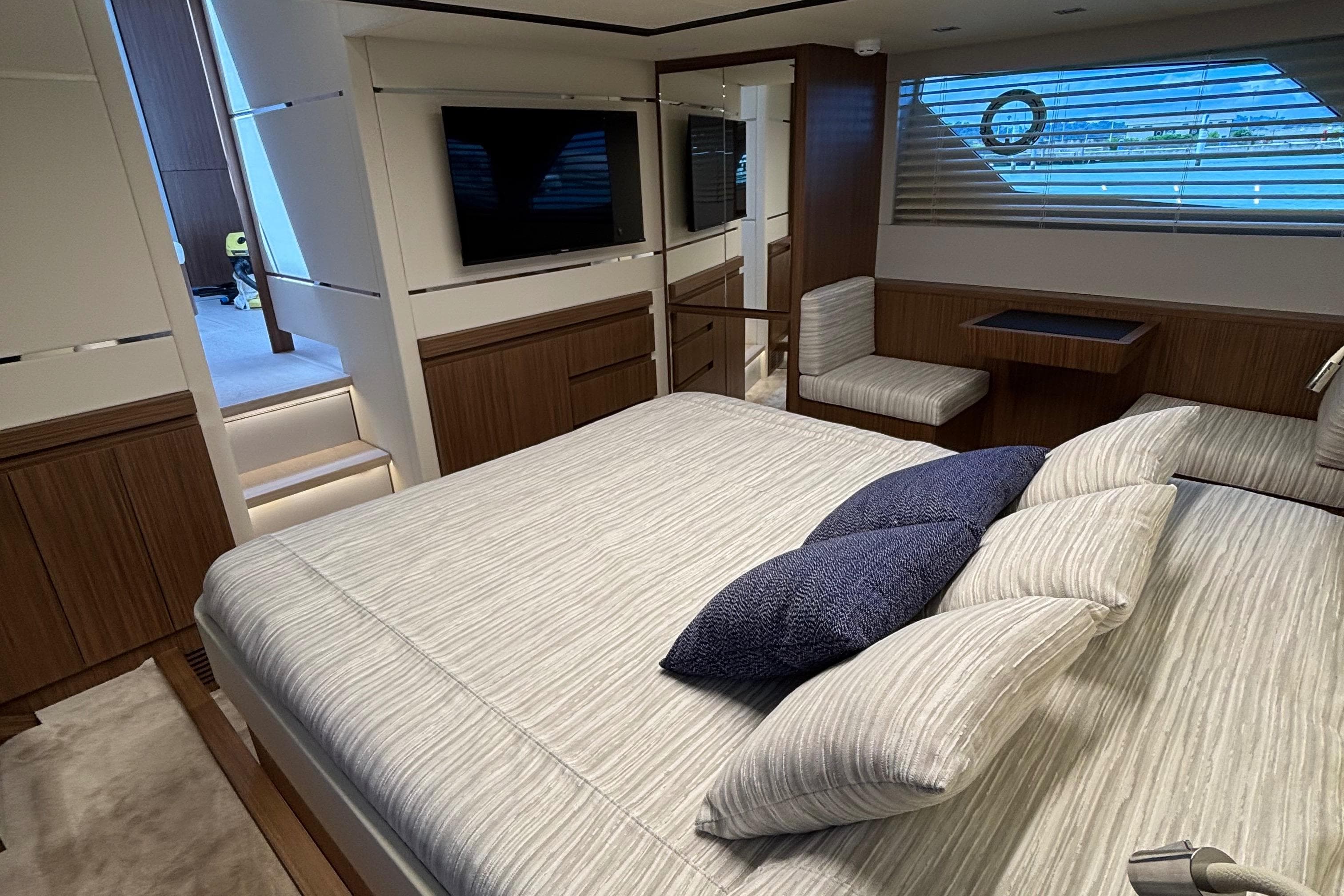 Luxurious 2025 Filippetti S55 yacht bedroom with modern decor and large bed.