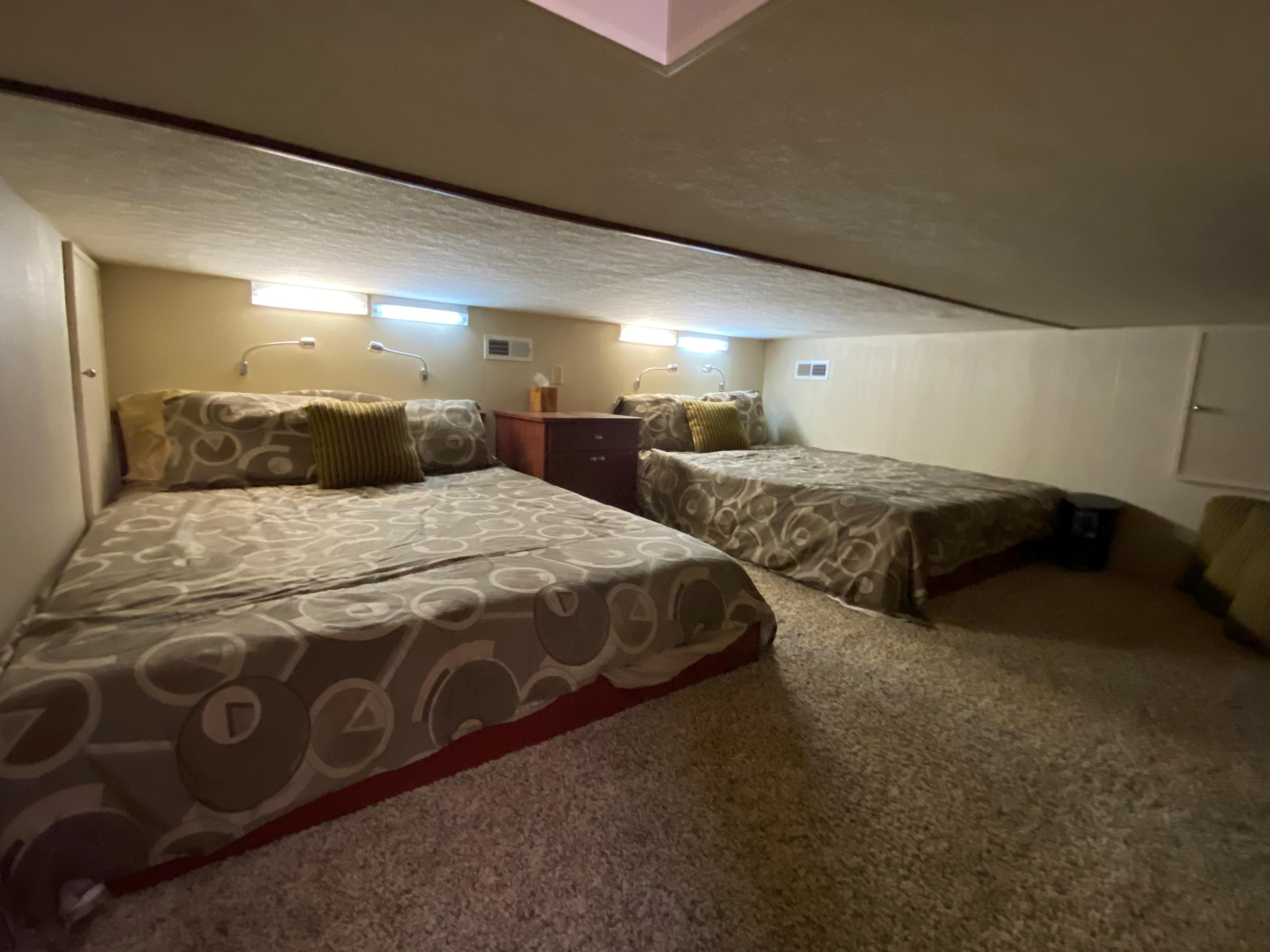 2005 Skipperliner Millenium interior with two beds, modern lighting, and cozy carpeted flooring.