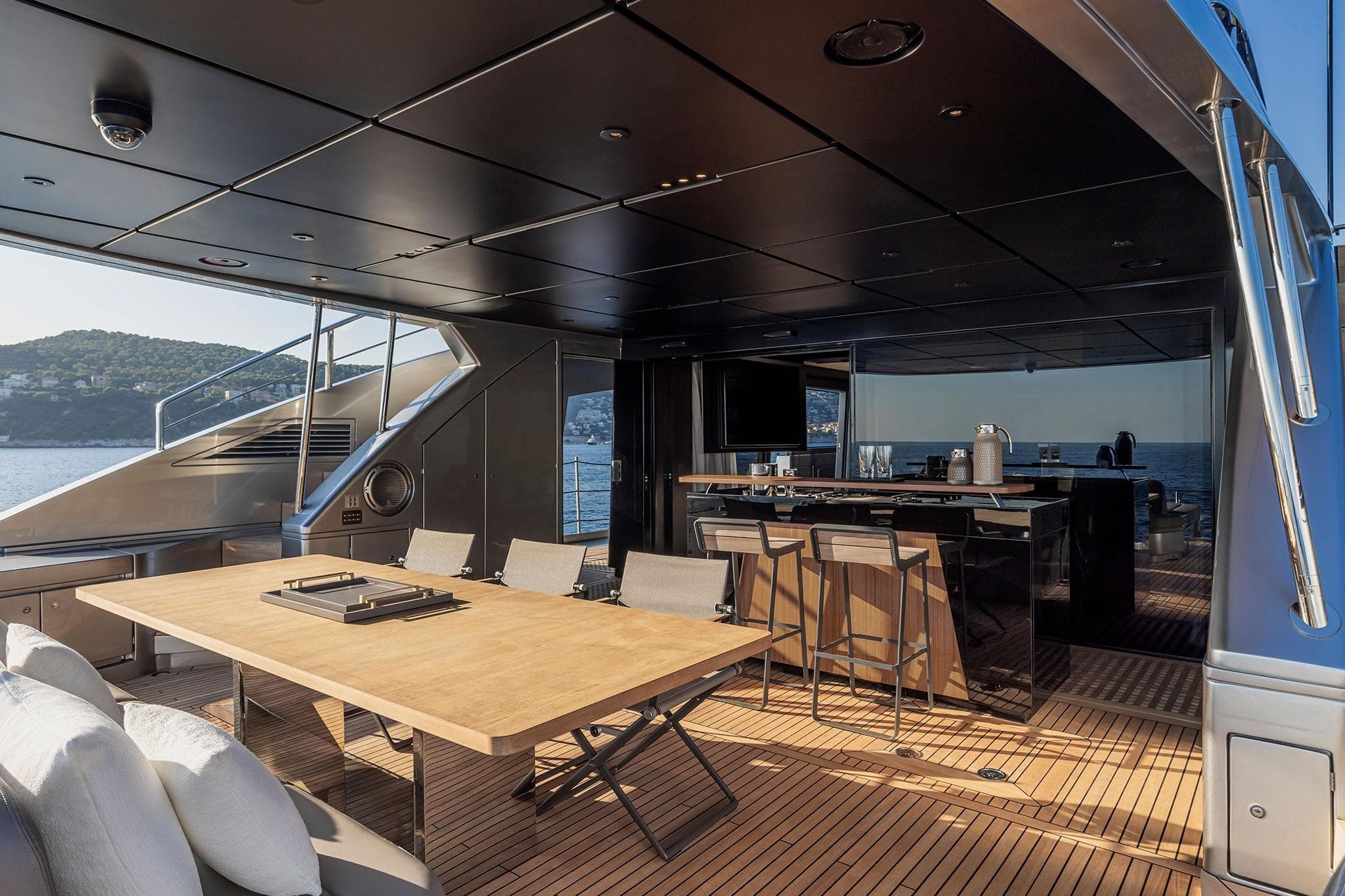 Luxurious 2025 Pershing GTX116 yacht deck with elegant dining and bar area.