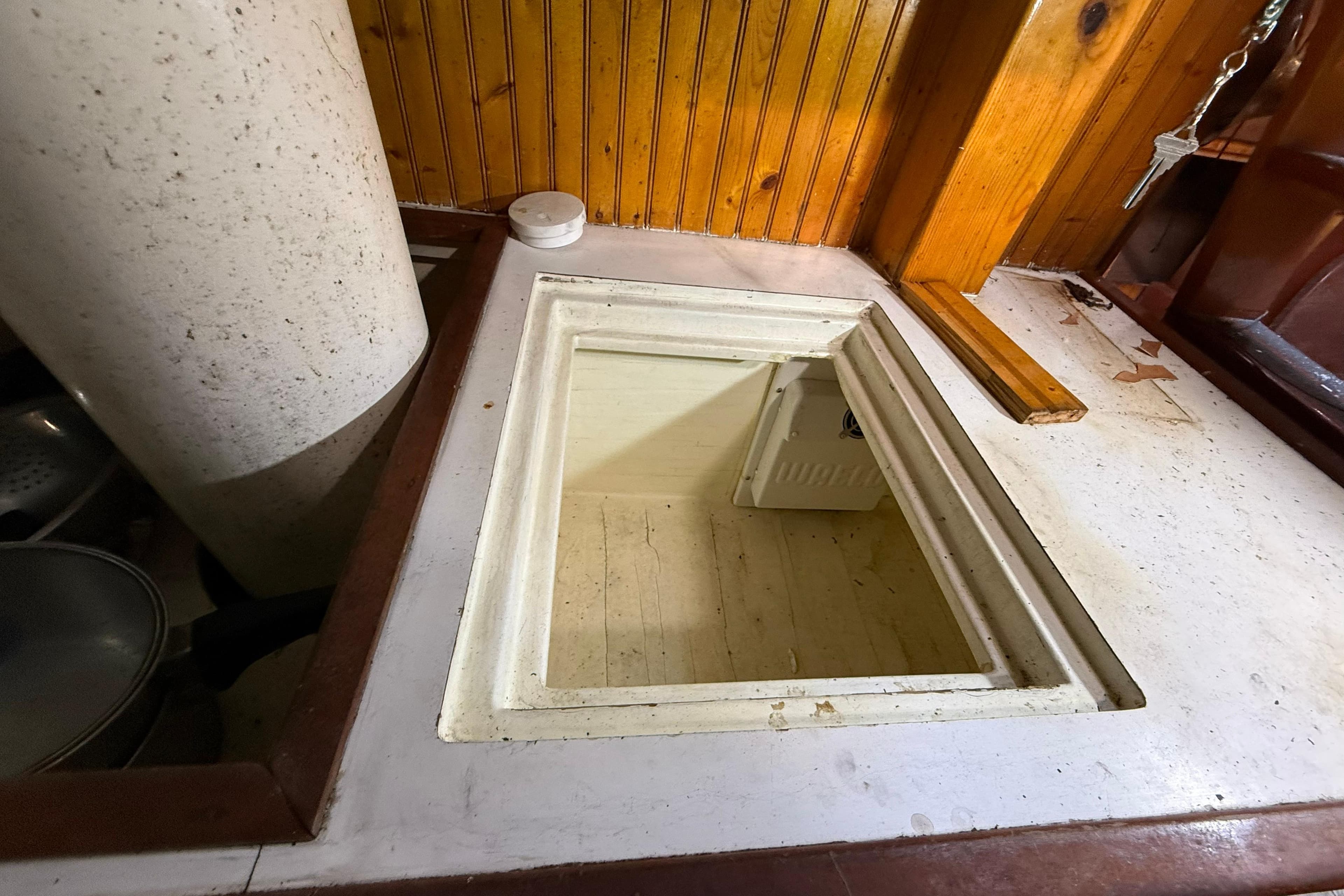 Interior view of a 1992 Treworgy 65 Schooner, featuring a wooden hatch and storage area.