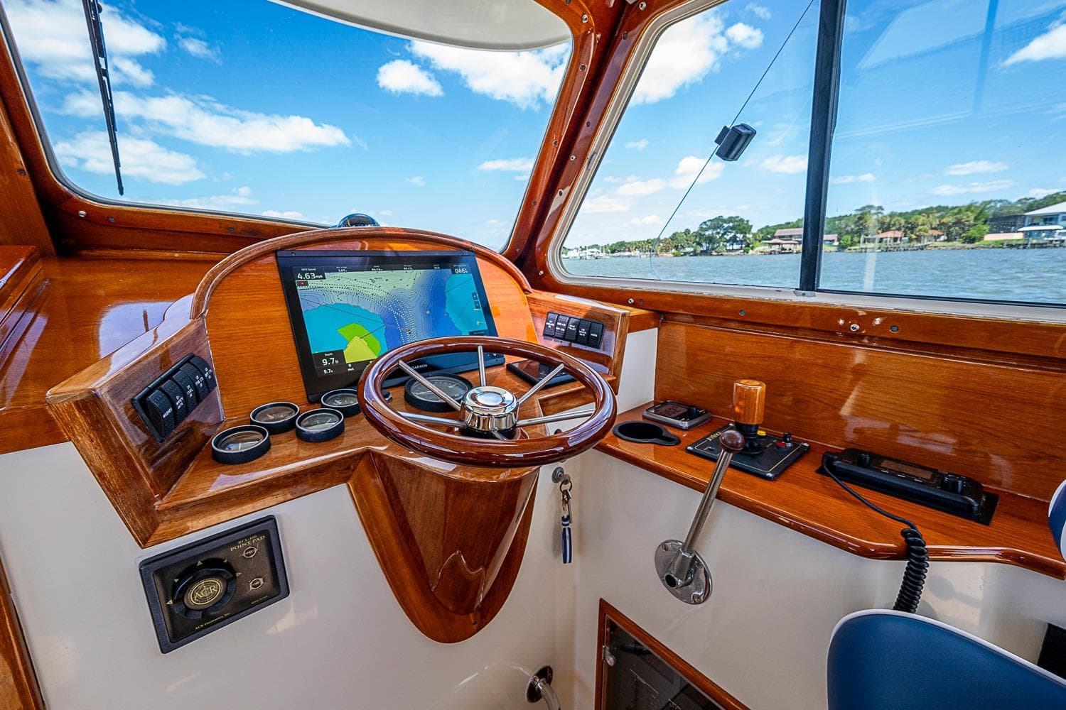 Helm of 2001 Hinckley Picnic Boat 36 Classic with navigation display and wooden finish.
