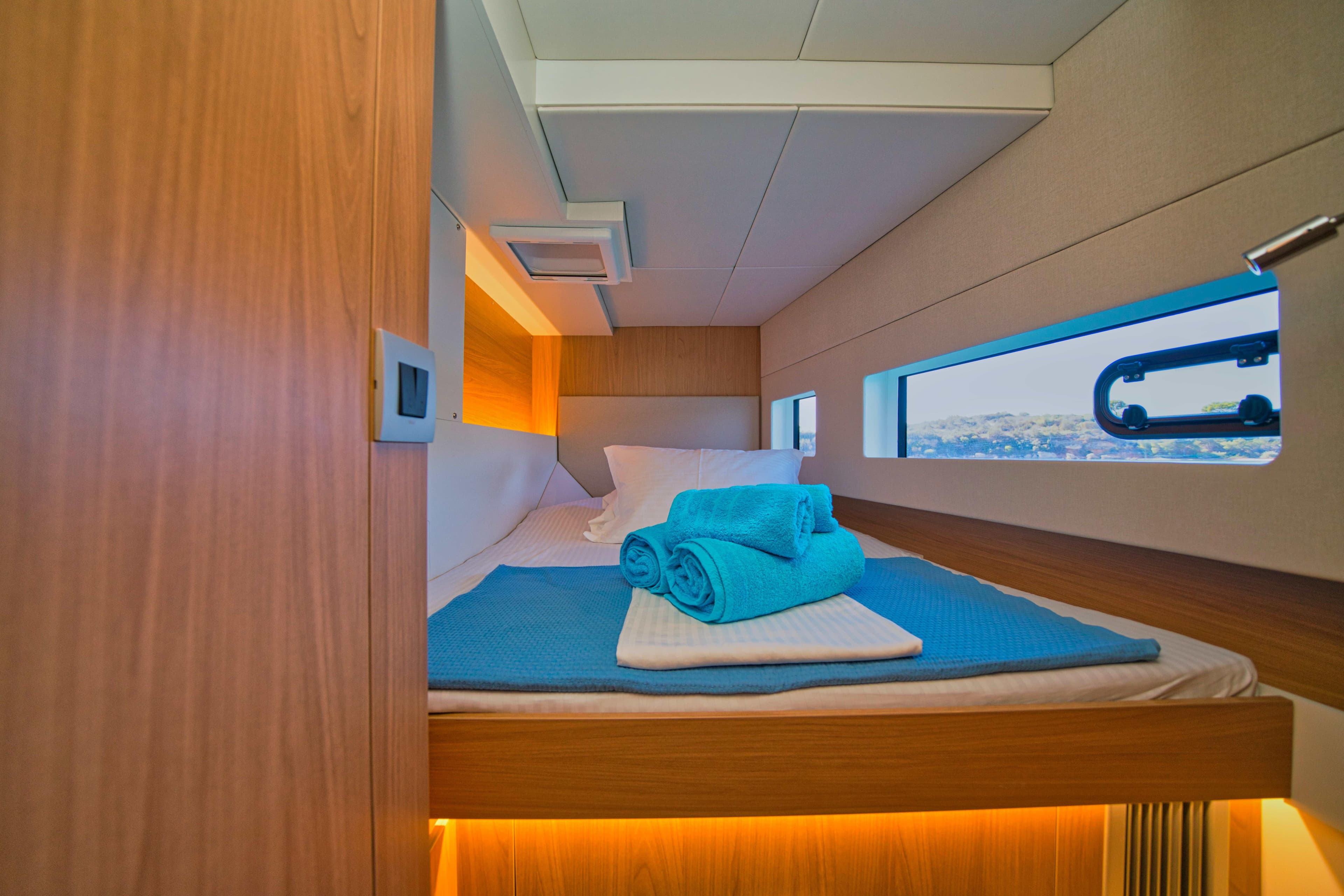 Cozy cabin interior of 2025 Bali CATSMART yacht with neatly arranged towels.