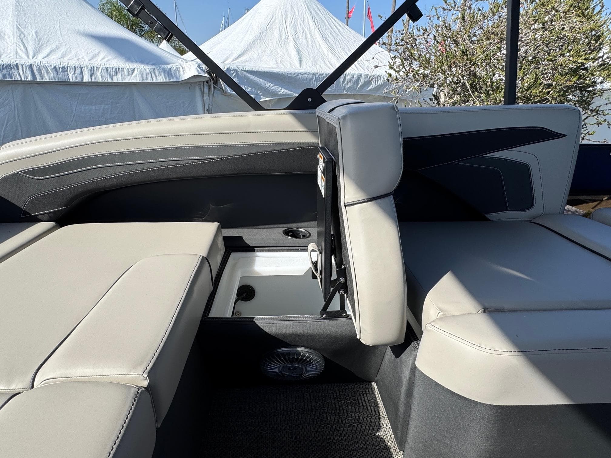 2026 Barletta Cabrio 24U boat interior with beige seating and storage compartment.