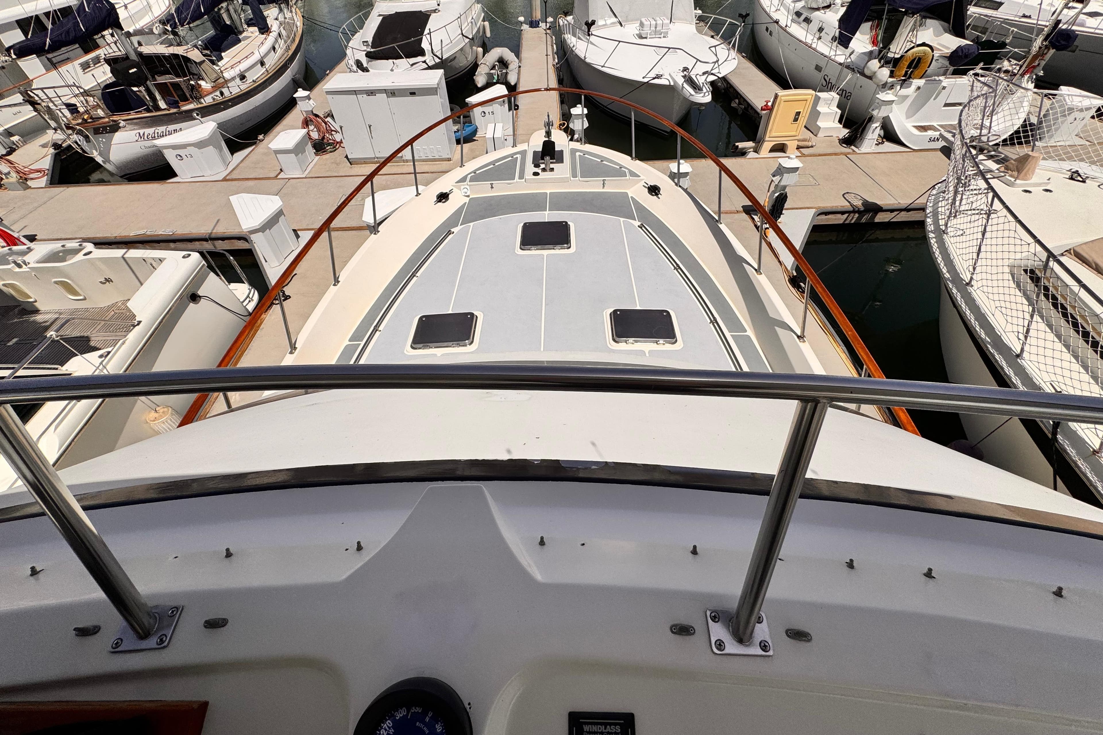 1988 Overseas PT52 Cockpit Motoryacht docked among other boats in a marina.