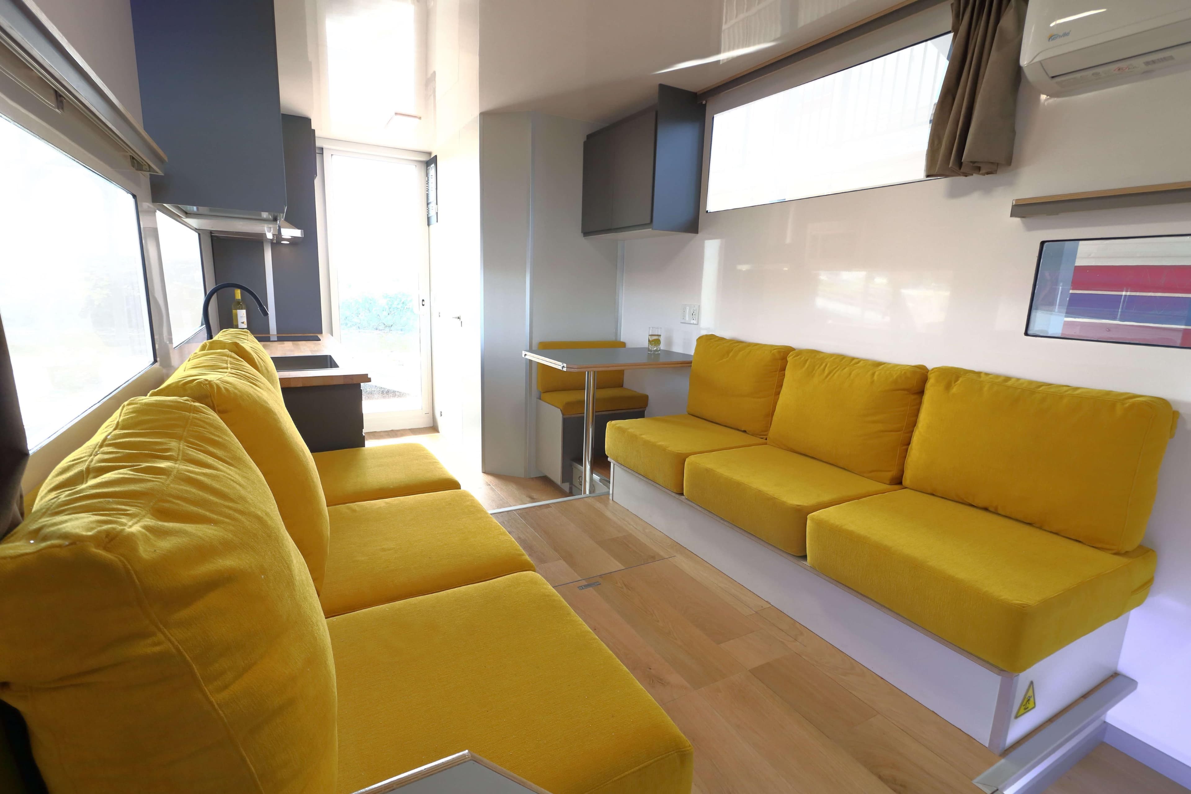 Modern Navisyo Homes NV.08 interior, 2021 model, featuring bright yellow seating and sleek design.