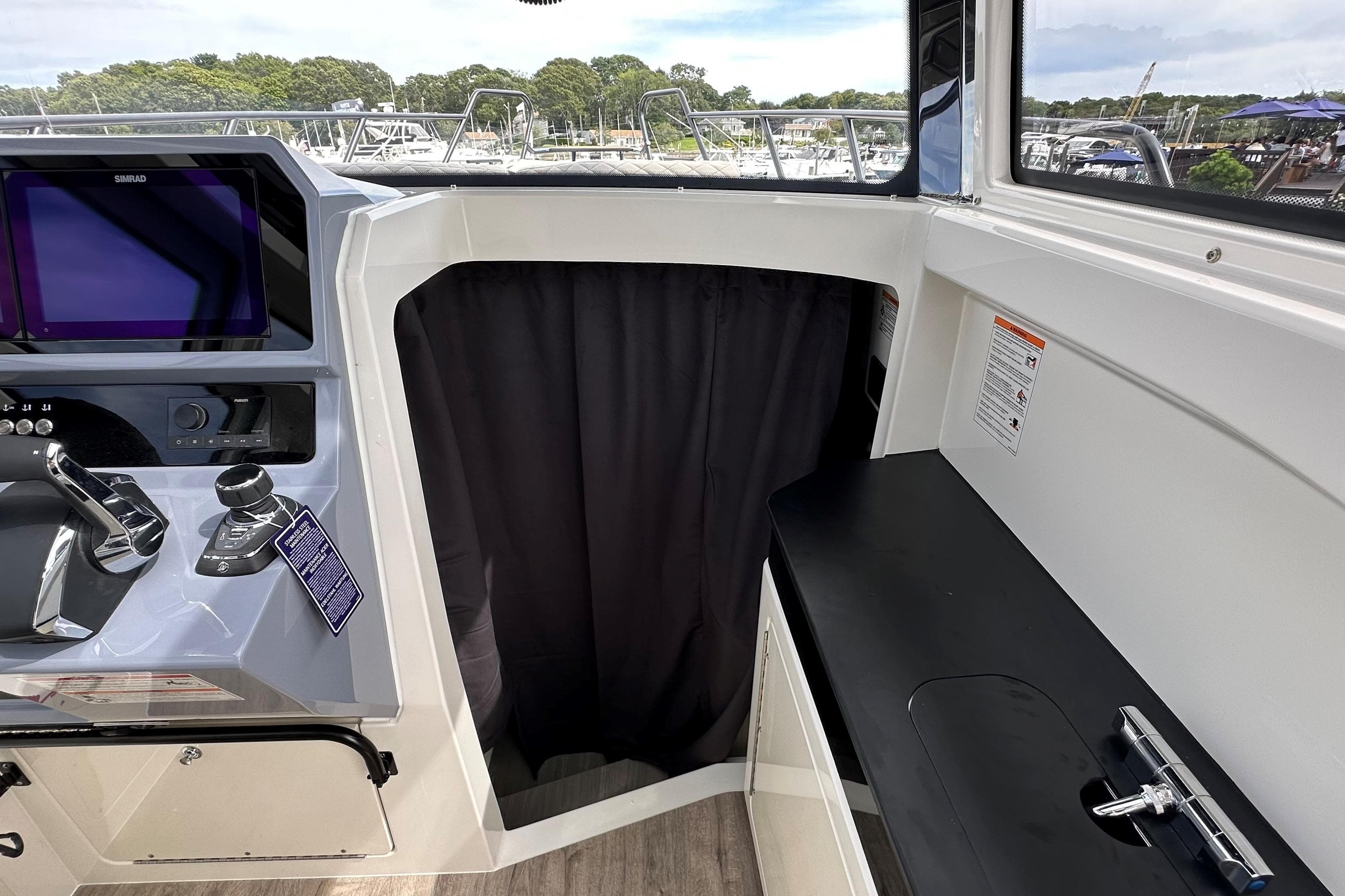 Interior view of 2025 Navan C30 boat cockpit with control panel and black curtain.