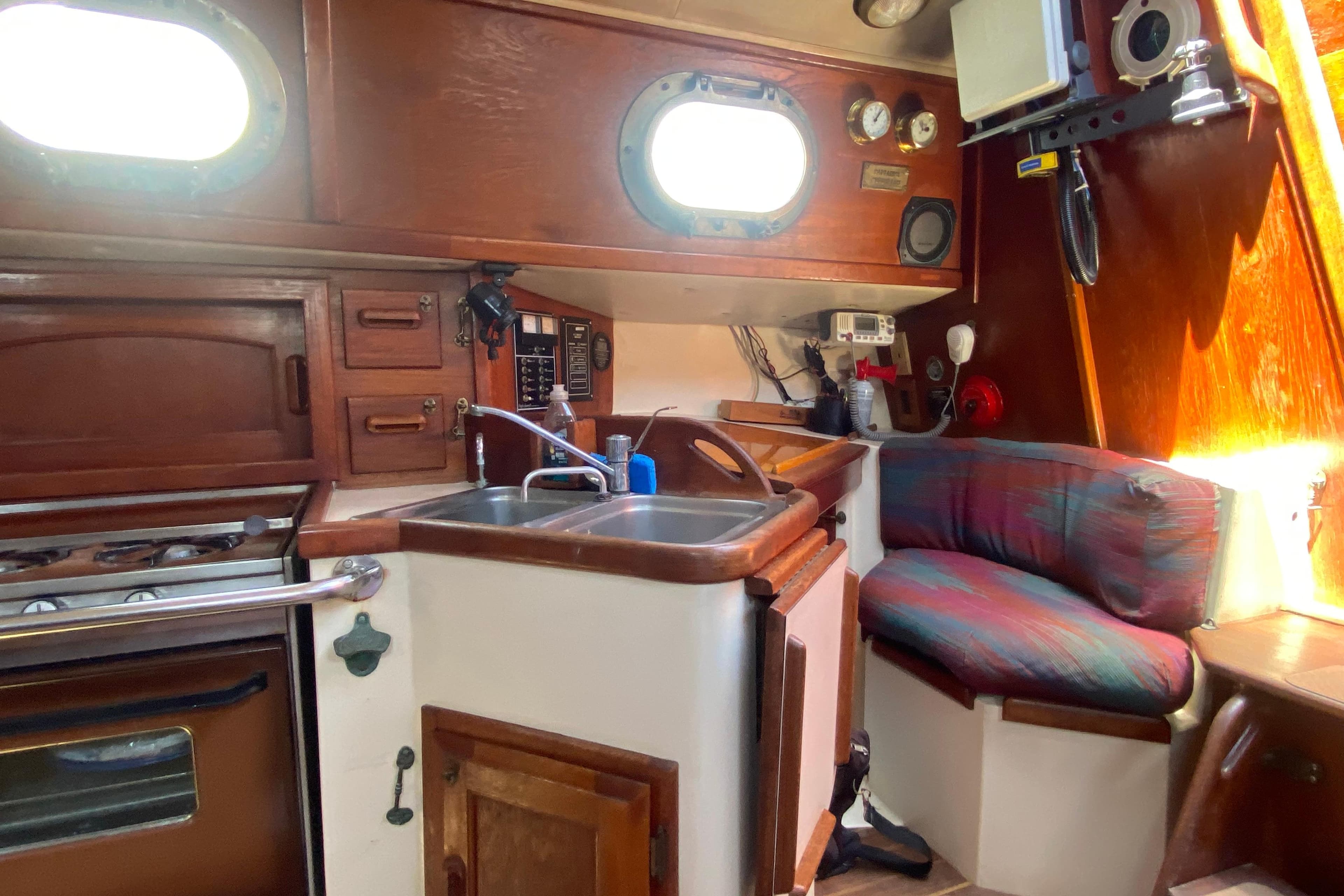 Cozy 1980 Pacific Seacraft Orion 27 yacht interior with kitchen and seating area.