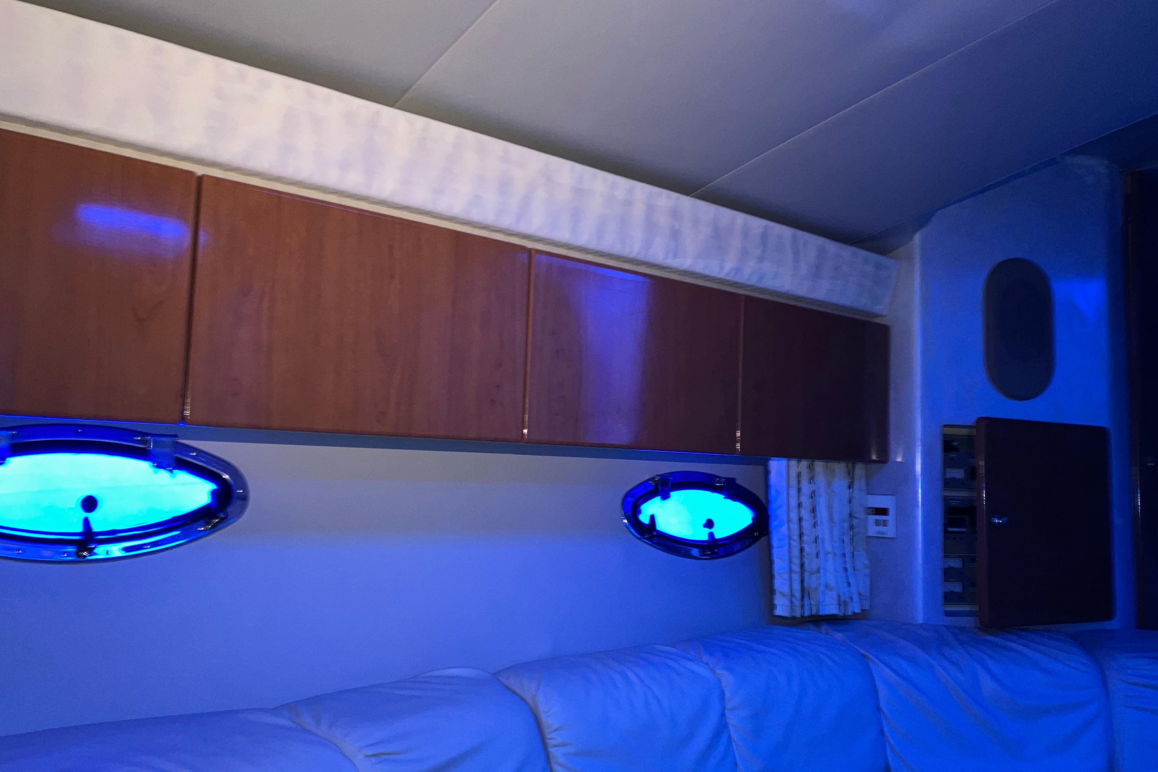 Interior of 2001 Formula 37 Performance Cruiser with blue-lit portholes and wooden cabinets.