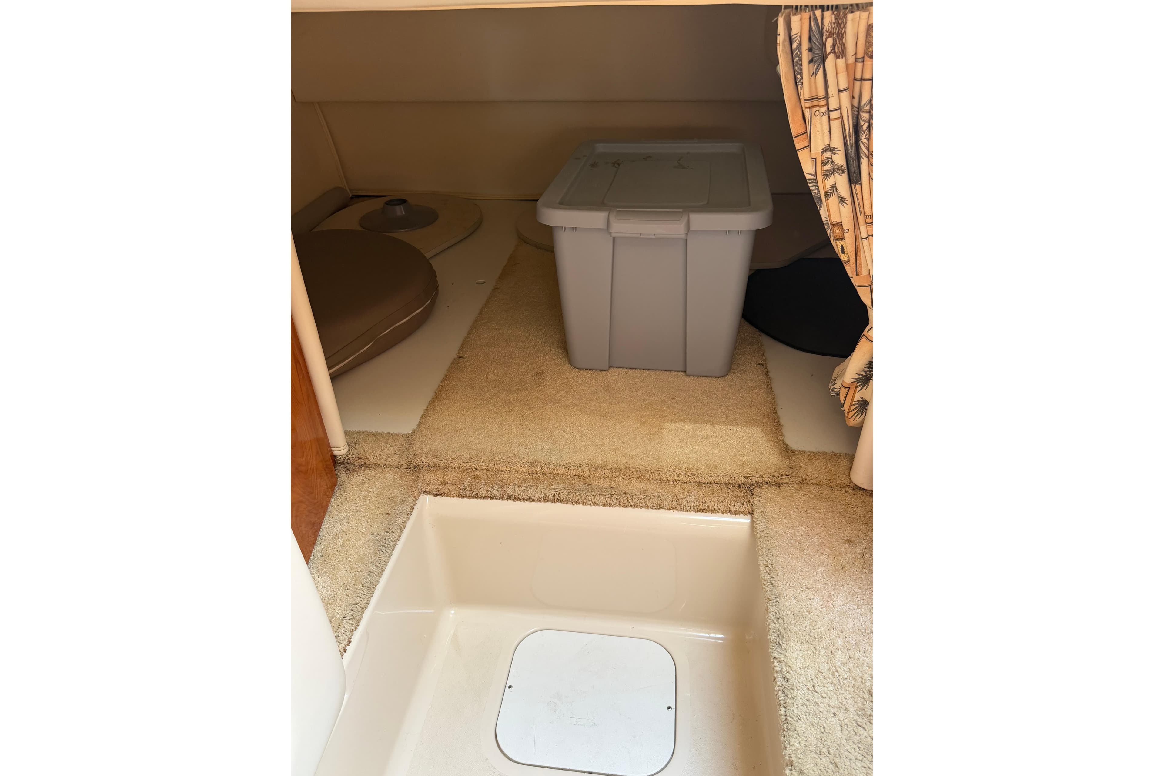 Interior cabin of 2004 Four Winns 268 Vista boat with storage bin and carpeted floor.