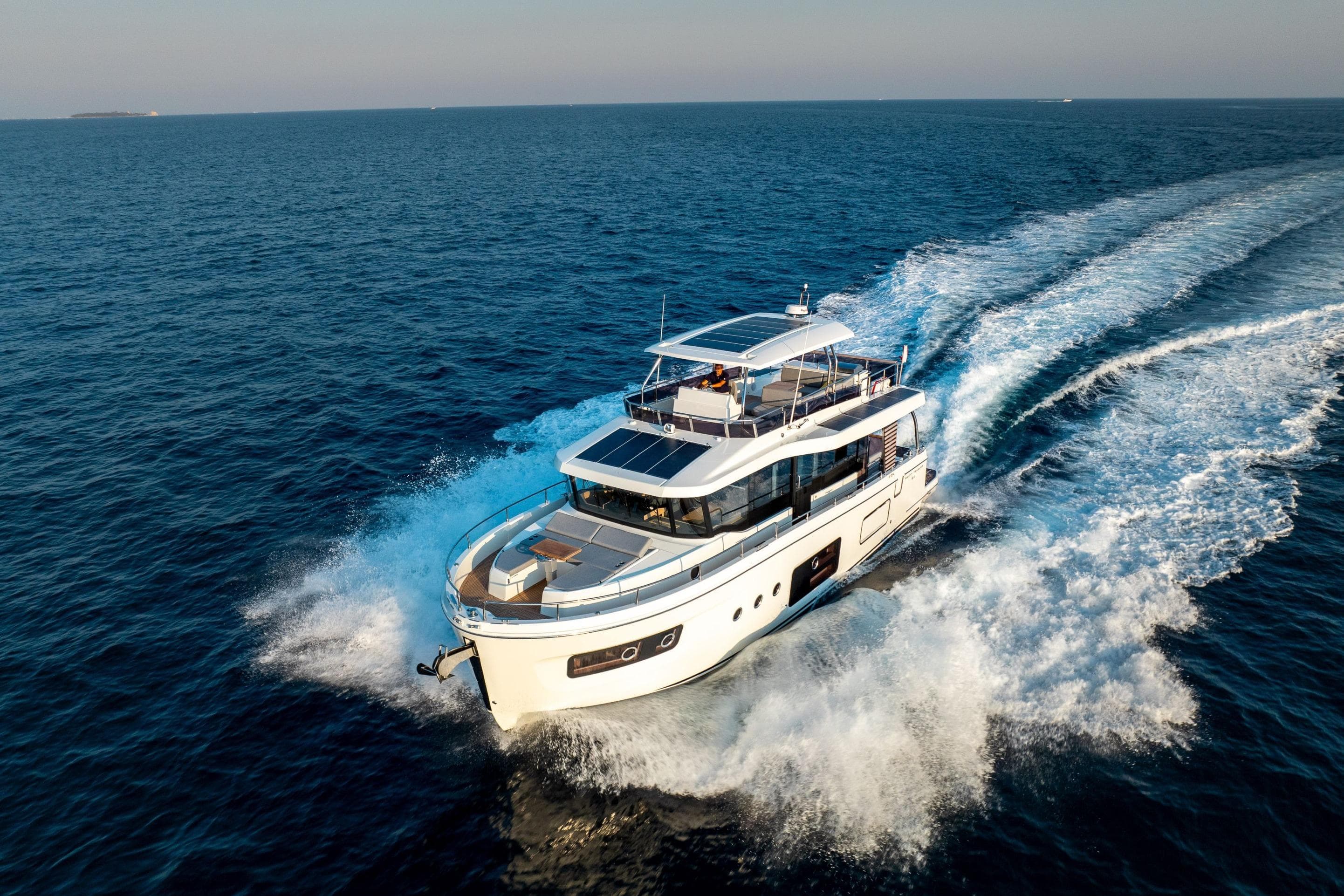 2026 Beneteau Swift Trawler 54 cruising on open sea, creating dynamic waves.