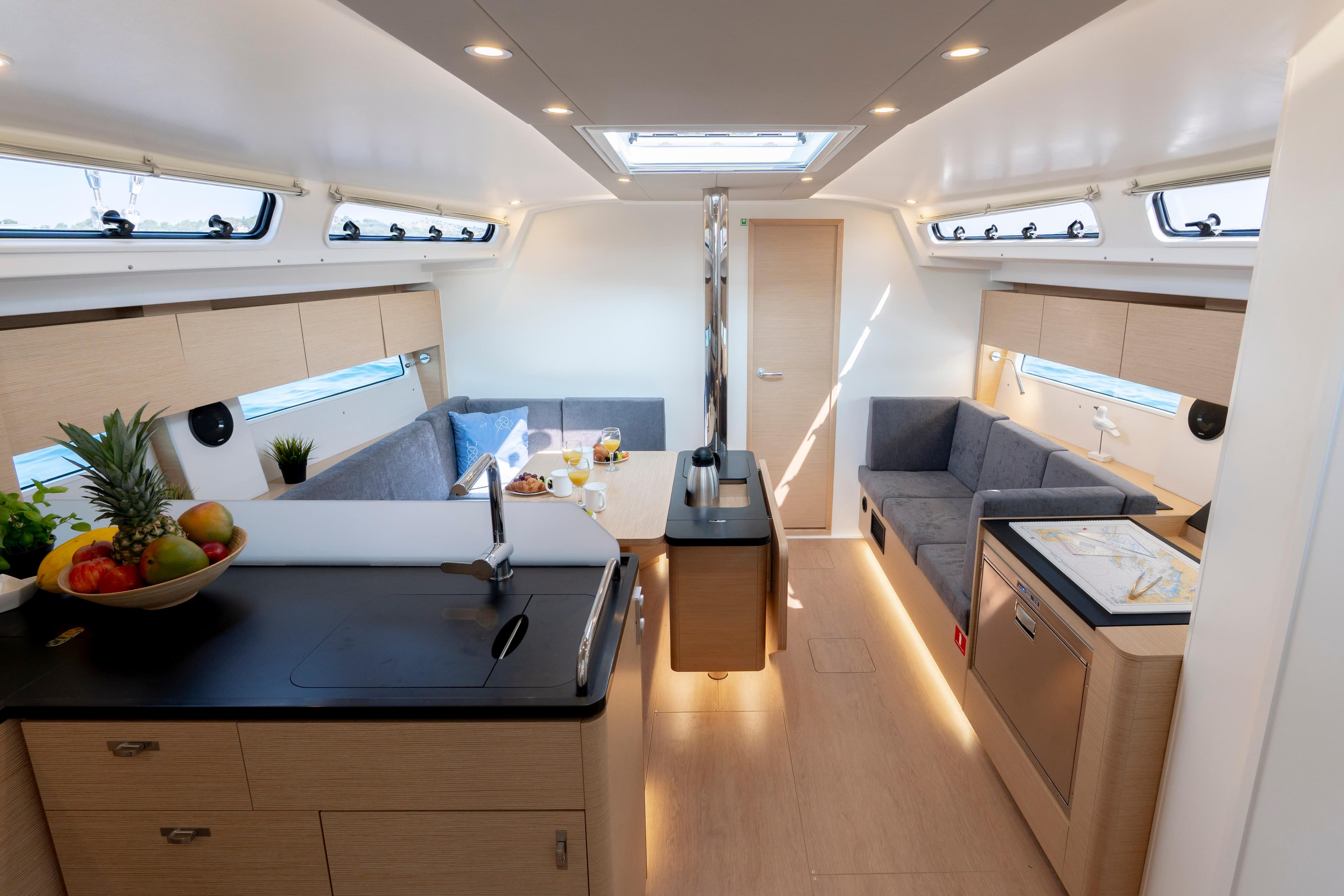 Modern interior of 2025 Hanse 410 yacht with sleek kitchen and cozy seating area.