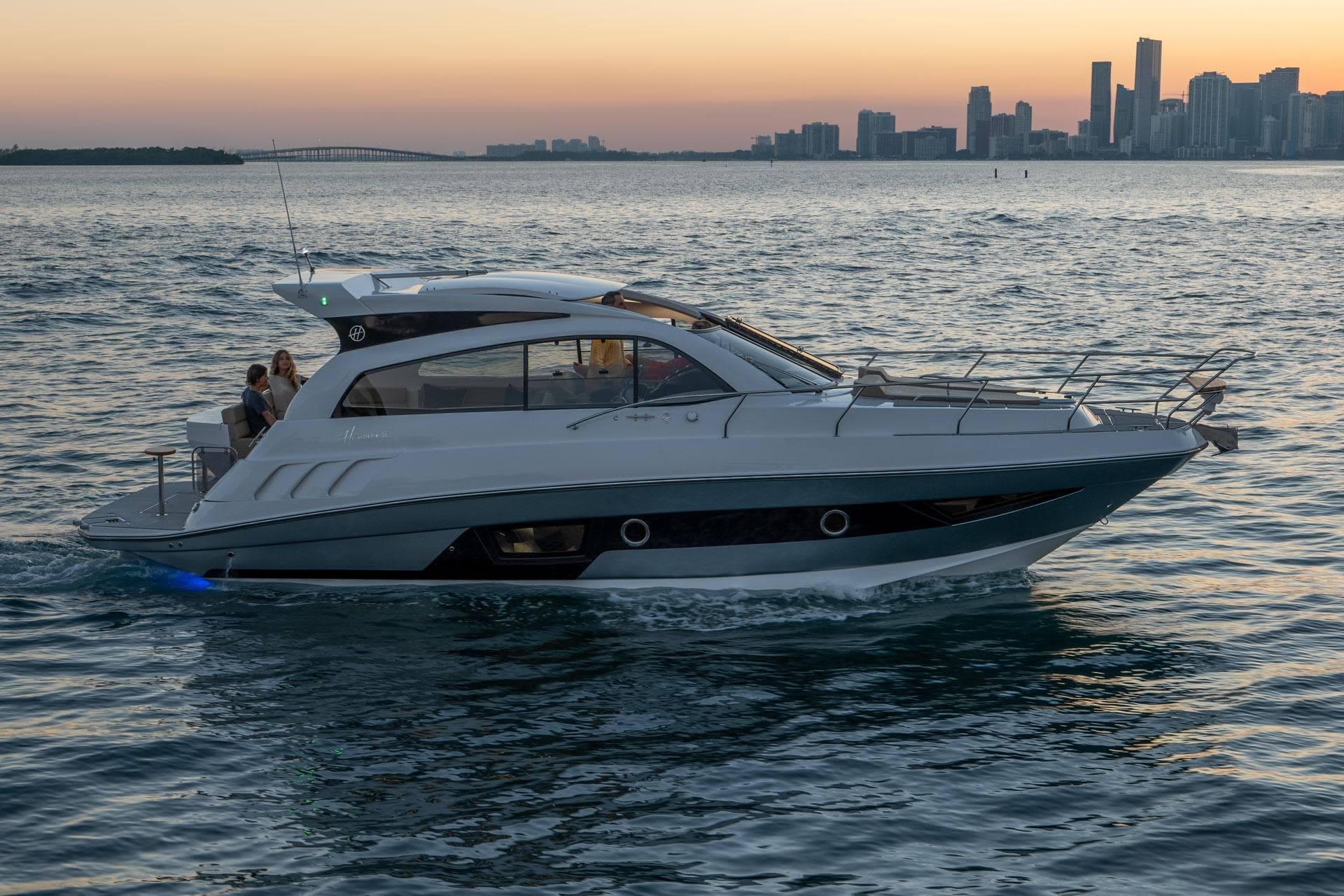 2026 Hanover 375 yacht cruising at sunset near city skyline.