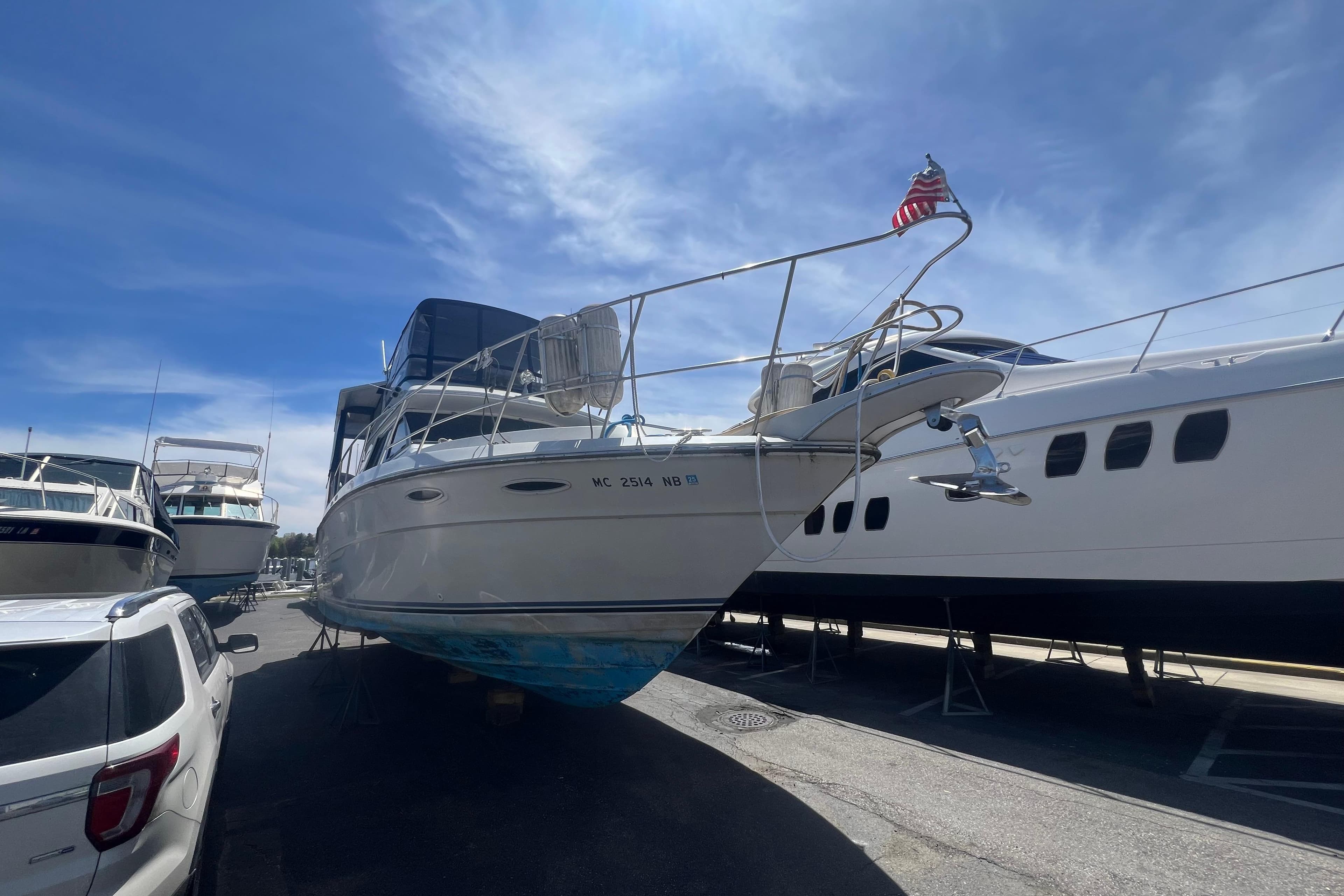 1987 Sea Ray 410 Aft Cabin yacht on dry dock under a clear blue sky.