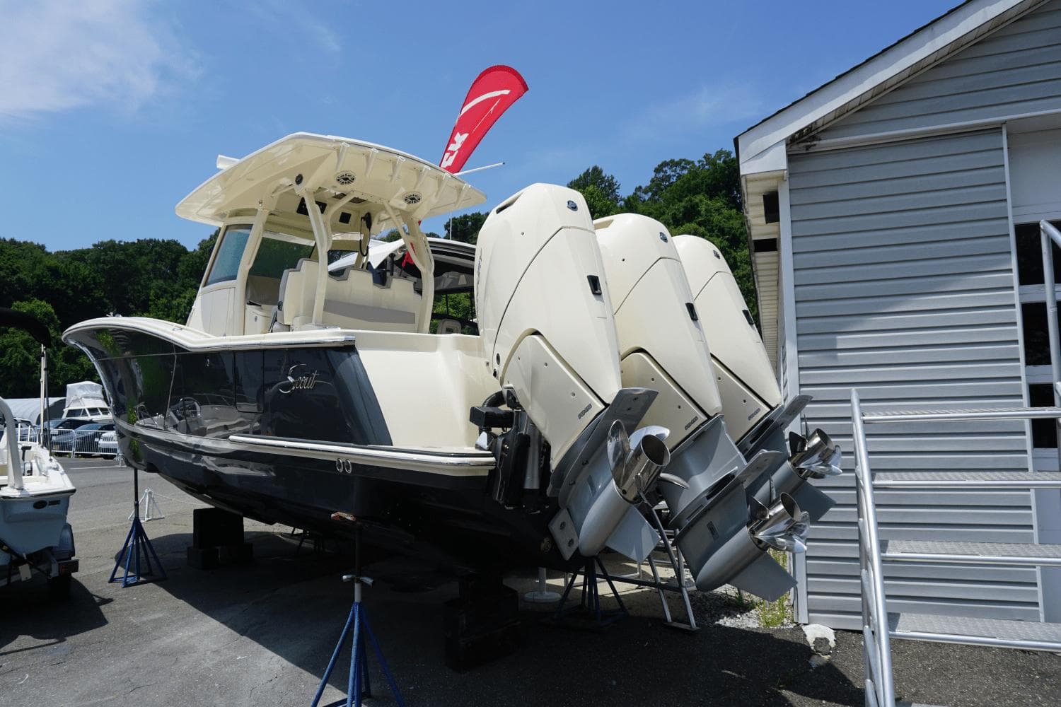 2024 Scout 357LXF boat with triple outboard engines on display outdoors.