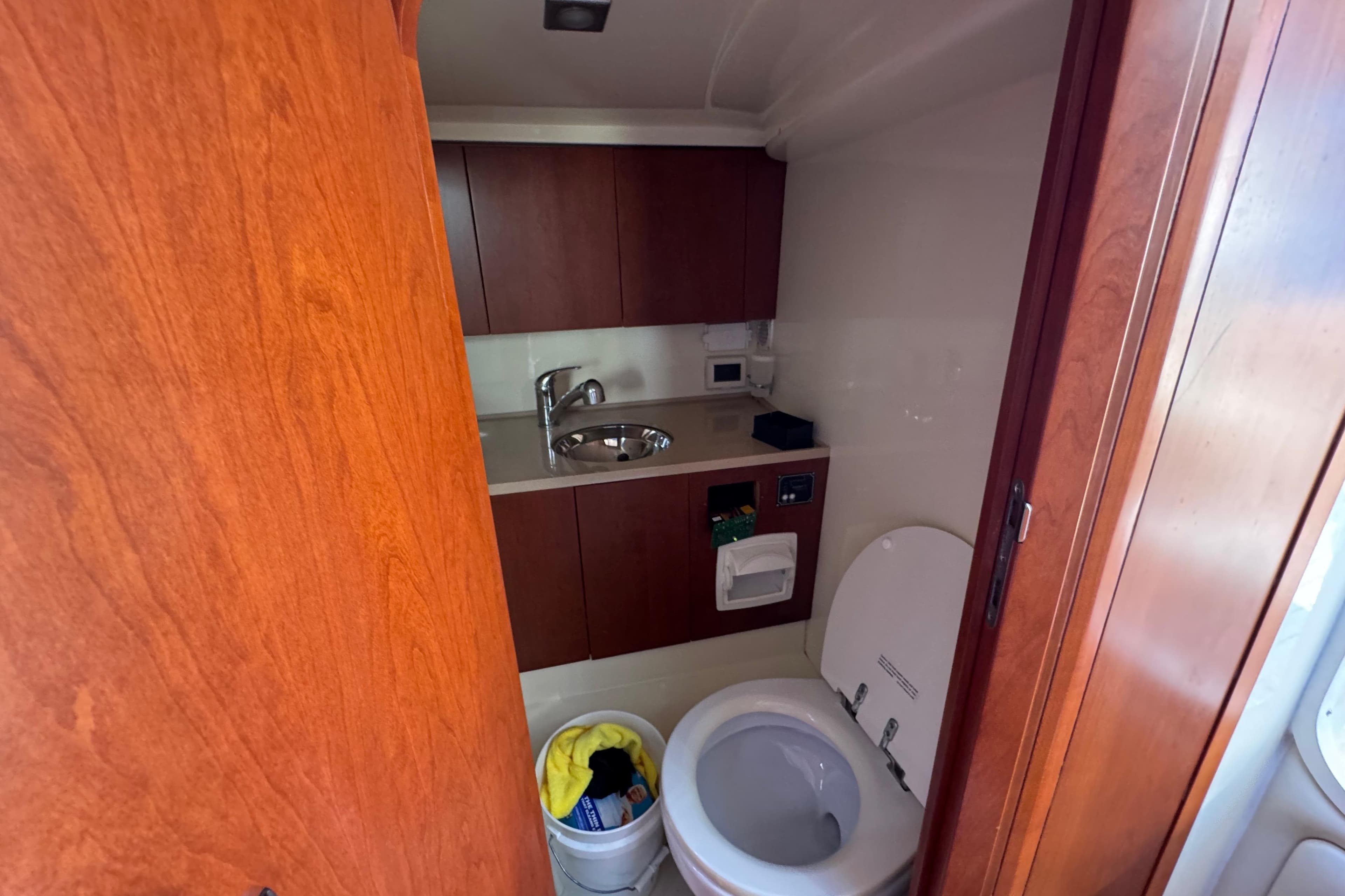 2015 Chris-Craft Corsair 32 boat bathroom with wooden cabinetry and modern fixtures.