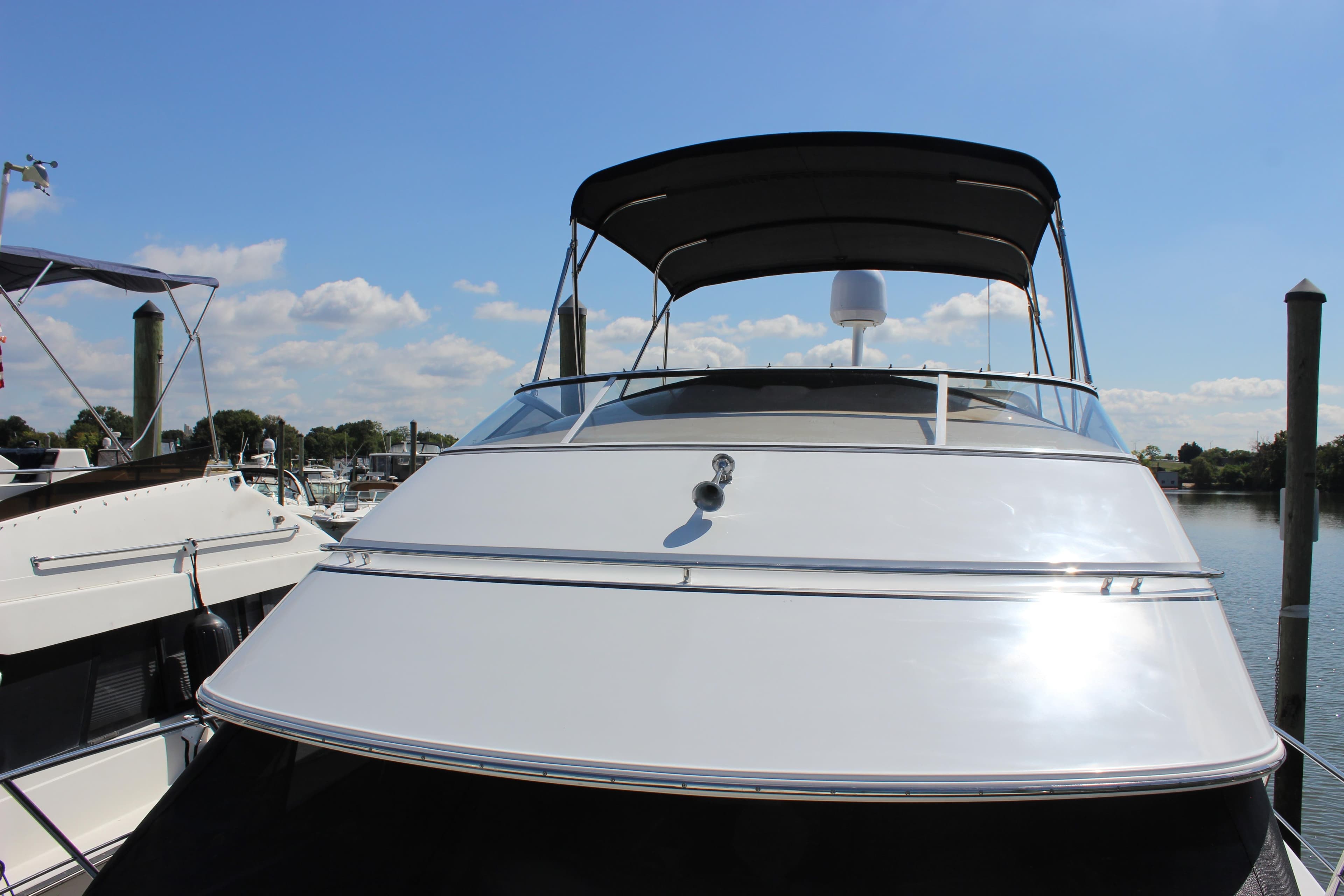 2003 Carver 36 Super Sport yacht docked under clear blue sky.