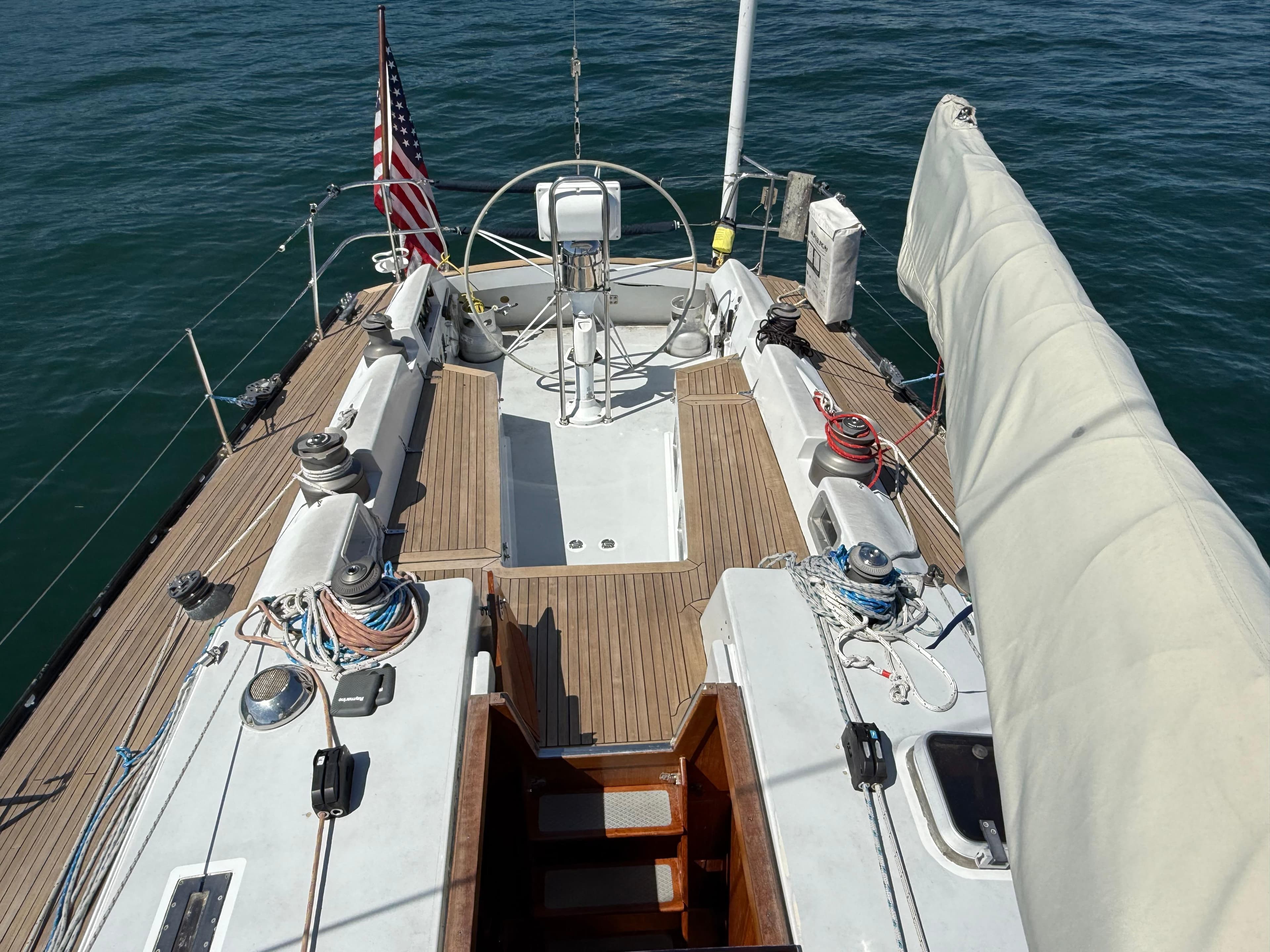 1986 Baltic Custom Farr 44 sailboat deck with wooden finish and American flag.