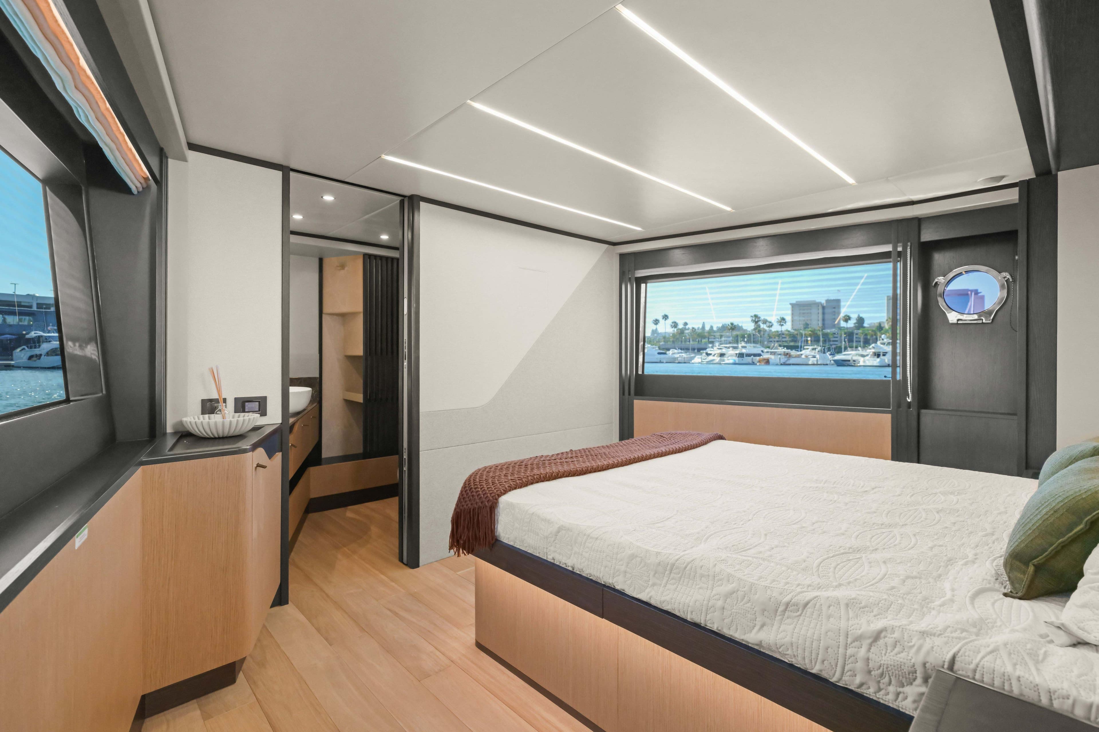 Luxurious interior of 2026 Absolute 52 Fly yacht with modern bedroom and scenic window view.