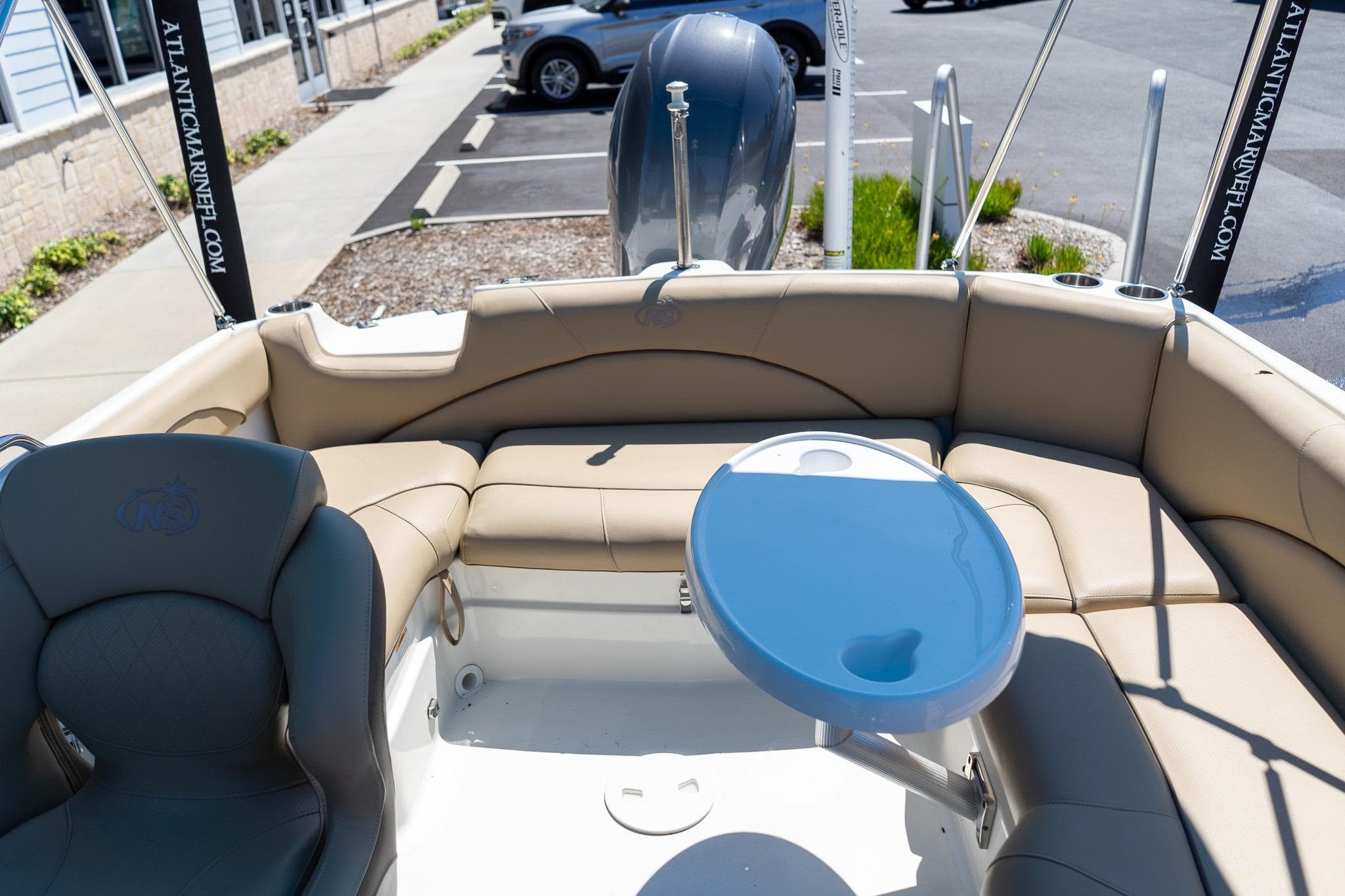 2020 NauticStar 203 SC boat interior with tan seating and blue table.