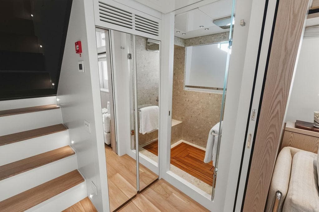 Luxurious interior of 2023 Sanlorenzo SD118 yacht featuring modern staircase and elegant bathroom.
