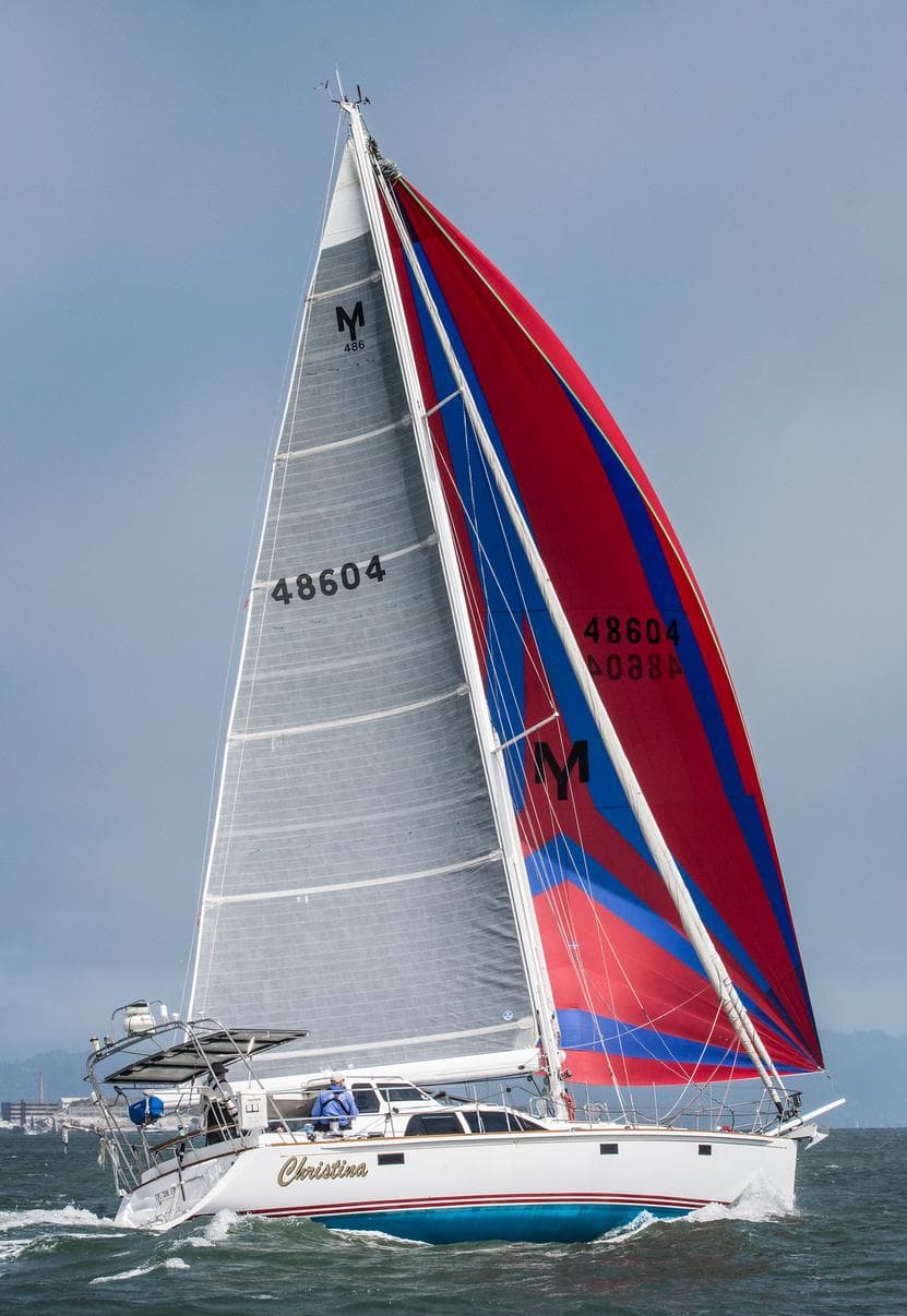 Sailing yacht Morris 486, 2005 model, with vibrant red and blue sails on open water.