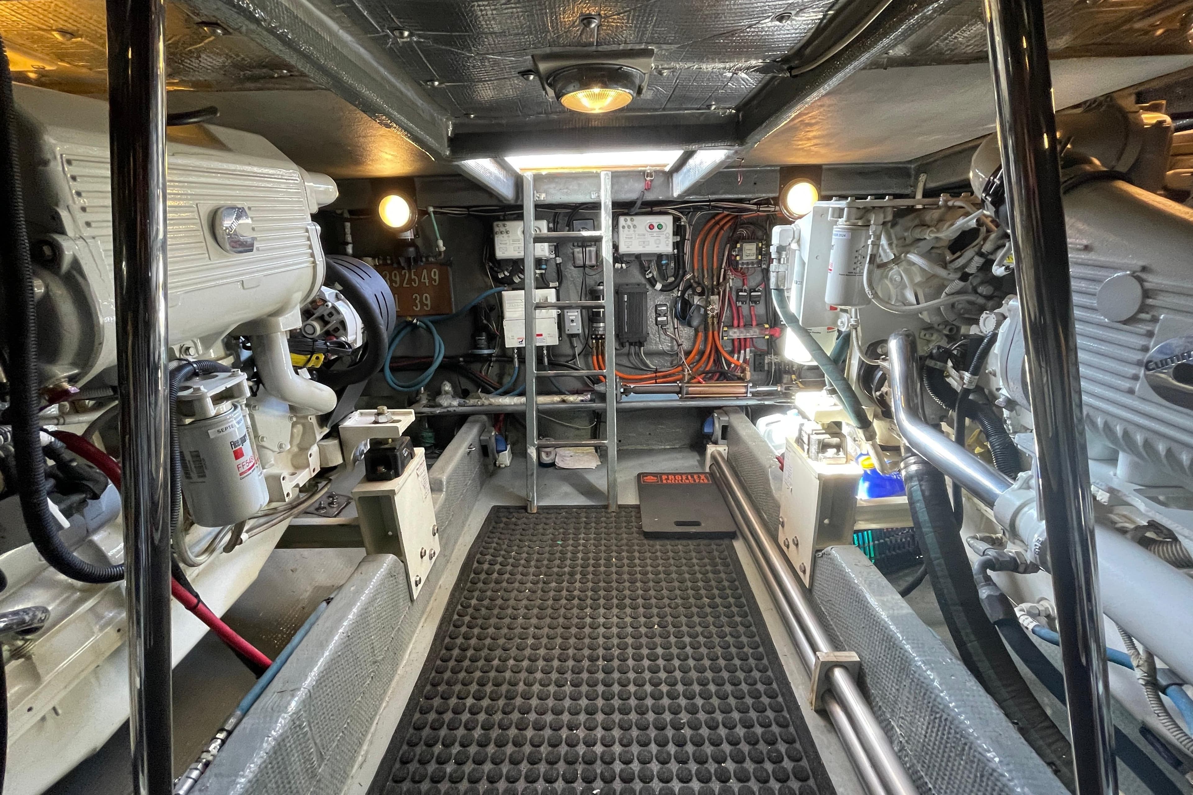 Engine room of a 1979 Canoe Cove 53 yacht, featuring dual engines and control systems.