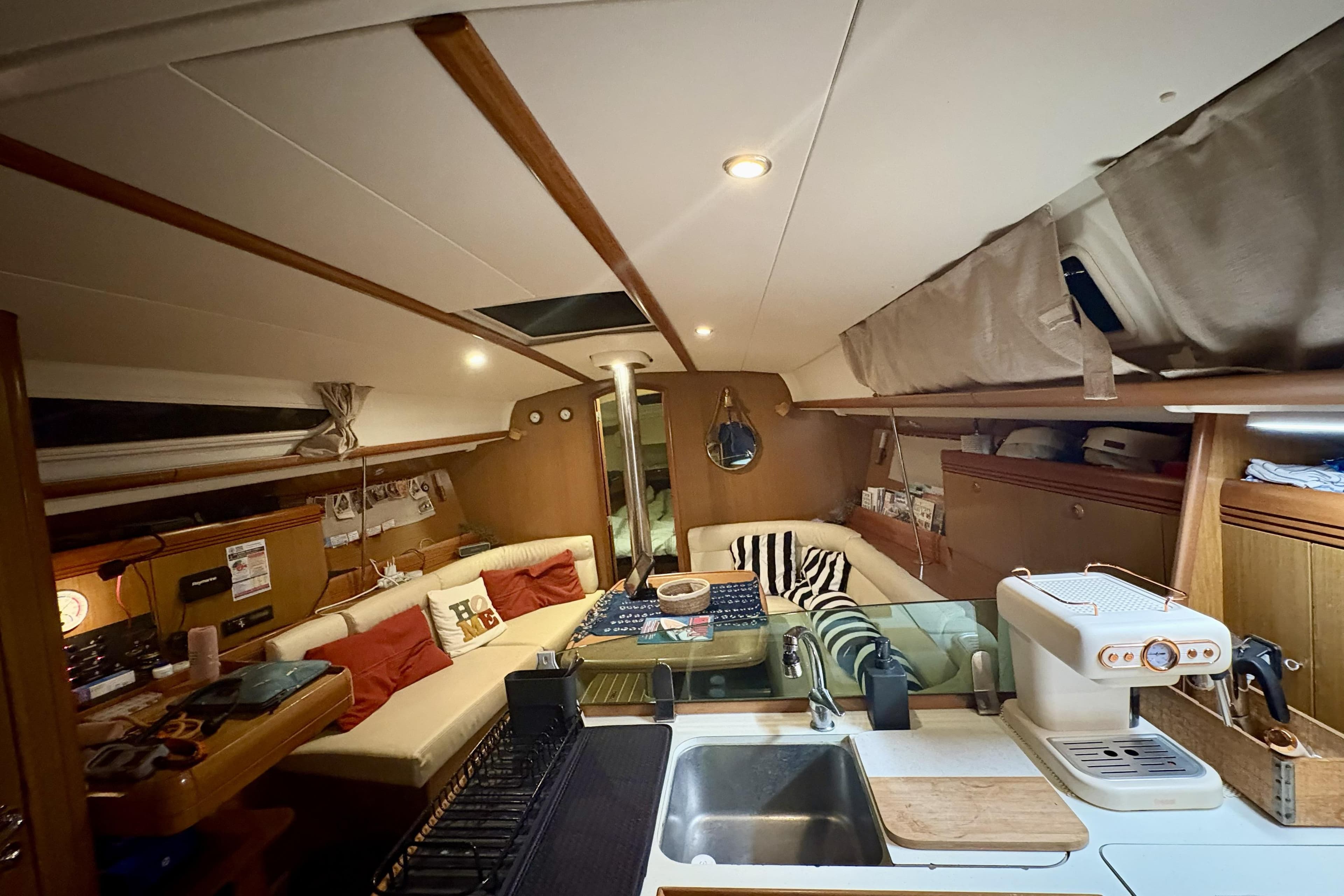 Interior of 2008 Jeanneau Sun Odyssey 39i yacht with cozy seating and kitchen area.