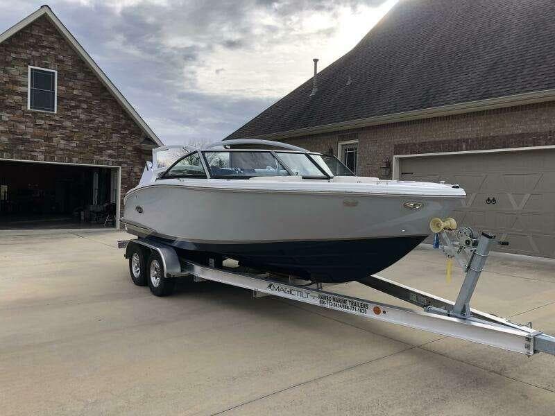 2022 Cobalt CS22 boat on trailer parked in driveway near brick house.