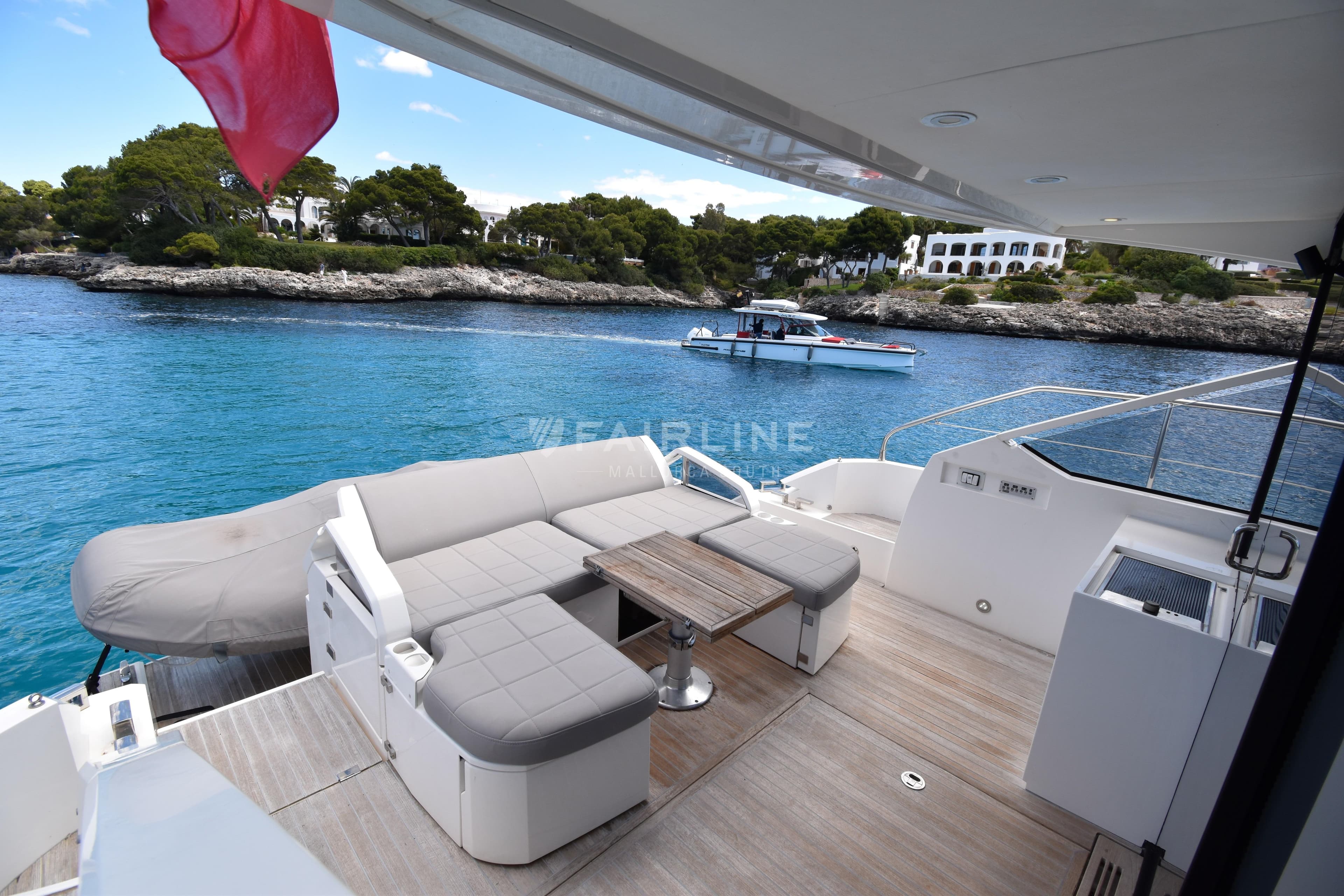 Luxurious 2012 Fairline Targa 50 GT yacht deck with seating, overlooking serene blue waters.