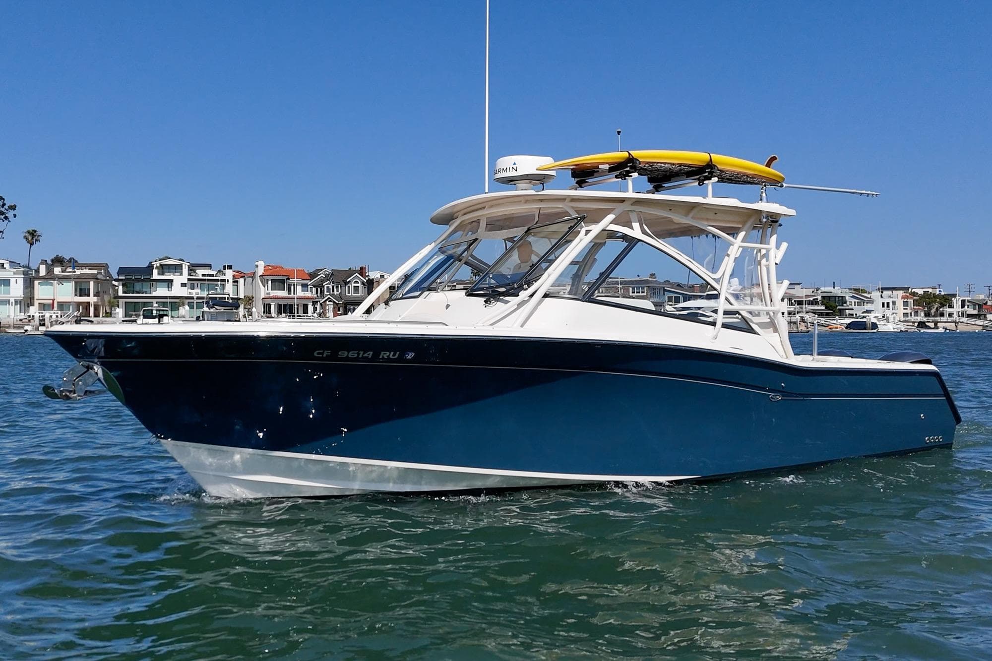 2016 Grady-White Freedom 335 boat on water, with coastal homes in the background.