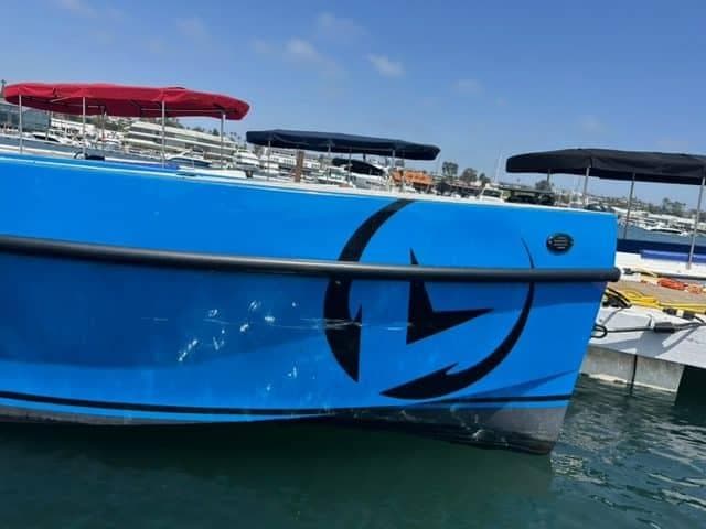 2023 Vision Marine Technologies Volt 180 boat docked, featuring a sleek blue design.