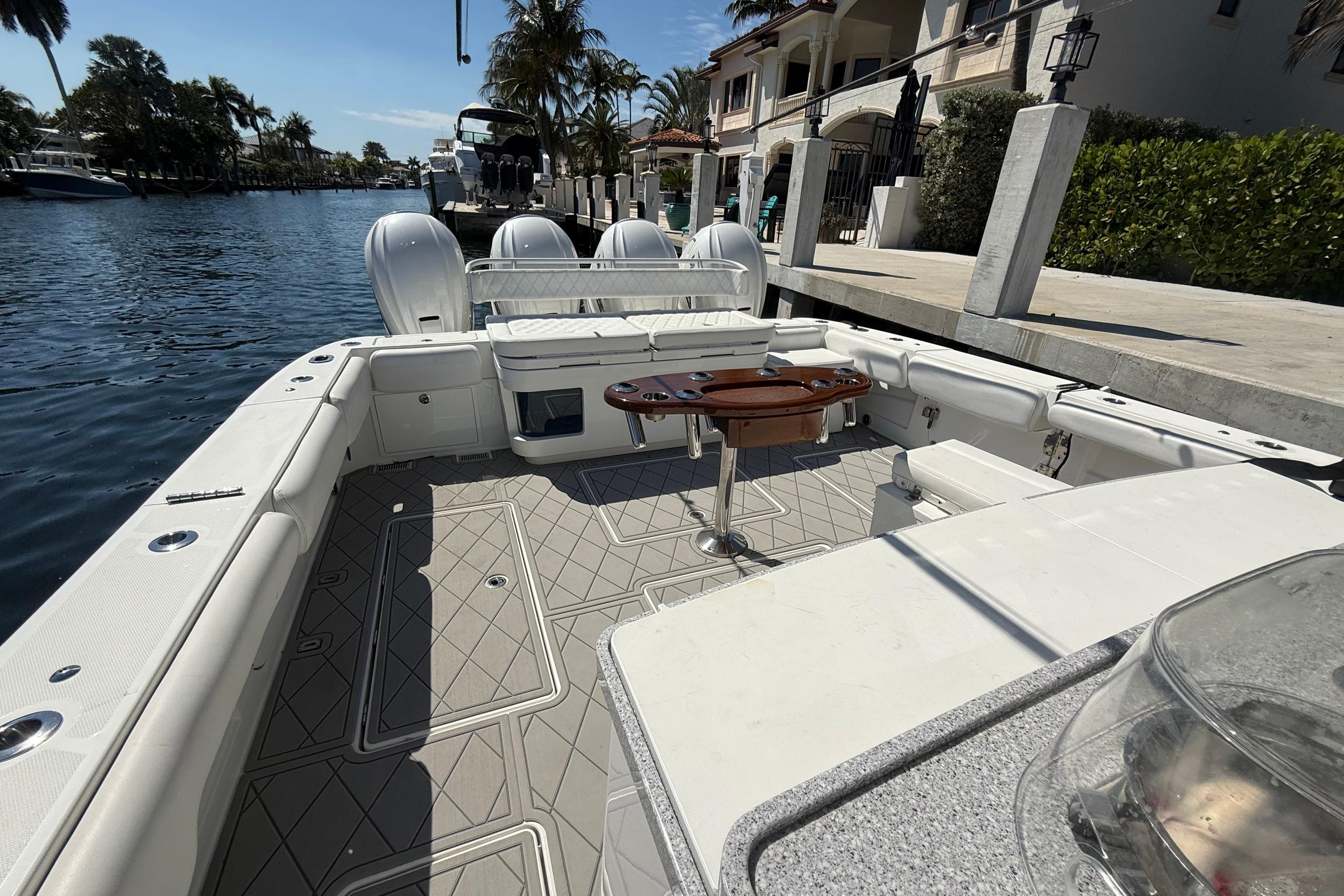 2019 HCB 53 Suenos boat interior with seating and table, docked by waterfront homes.