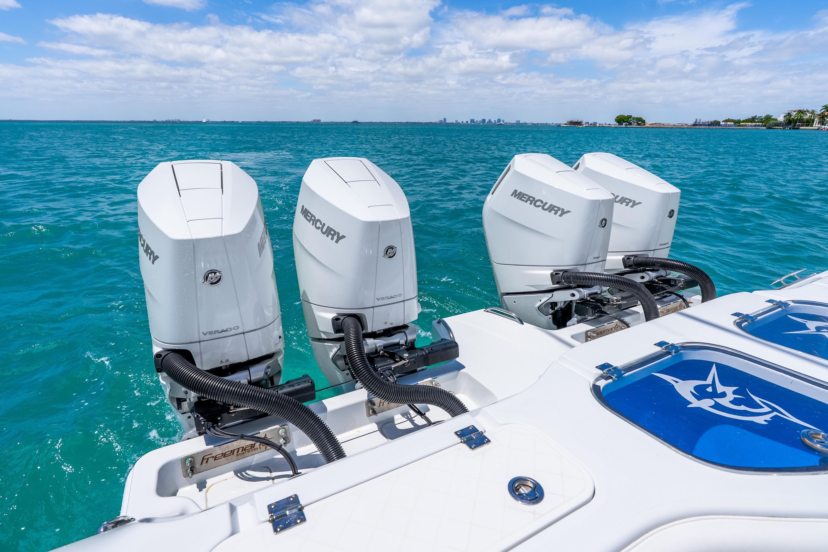 Freeman 43 boat with four Mercury outboard engines on turquoise water, 2025 model.