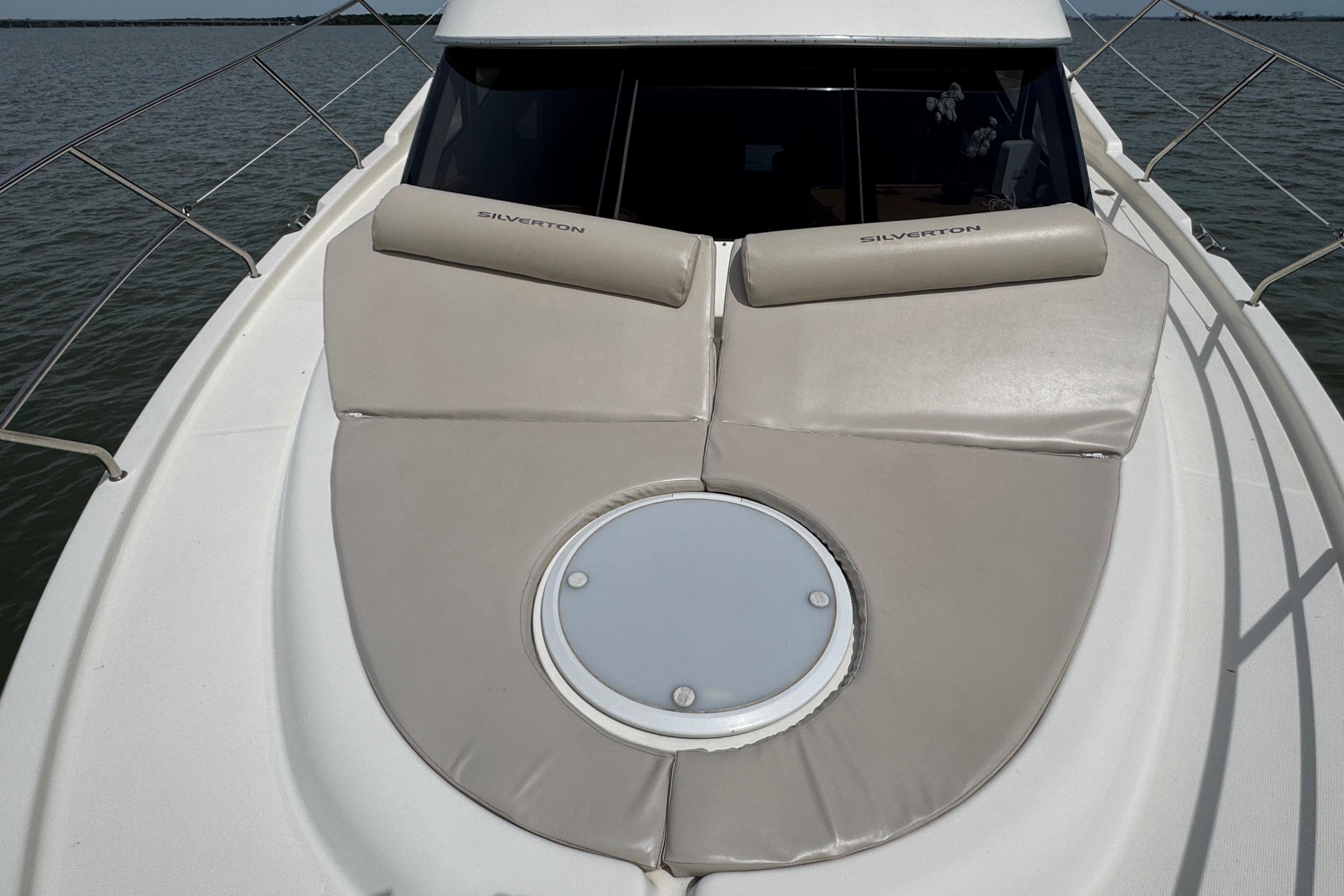 2003 Silverton 39 Motor Yacht deck with cushioned seating and circular hatch.