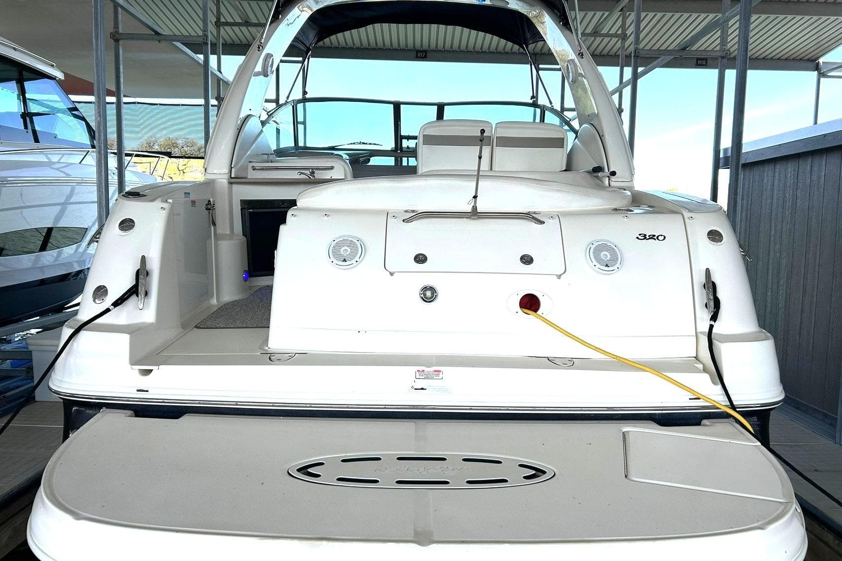 2006 Sea Ray Sundancer 320 yacht docked, rear view showcasing deck and seating area.
