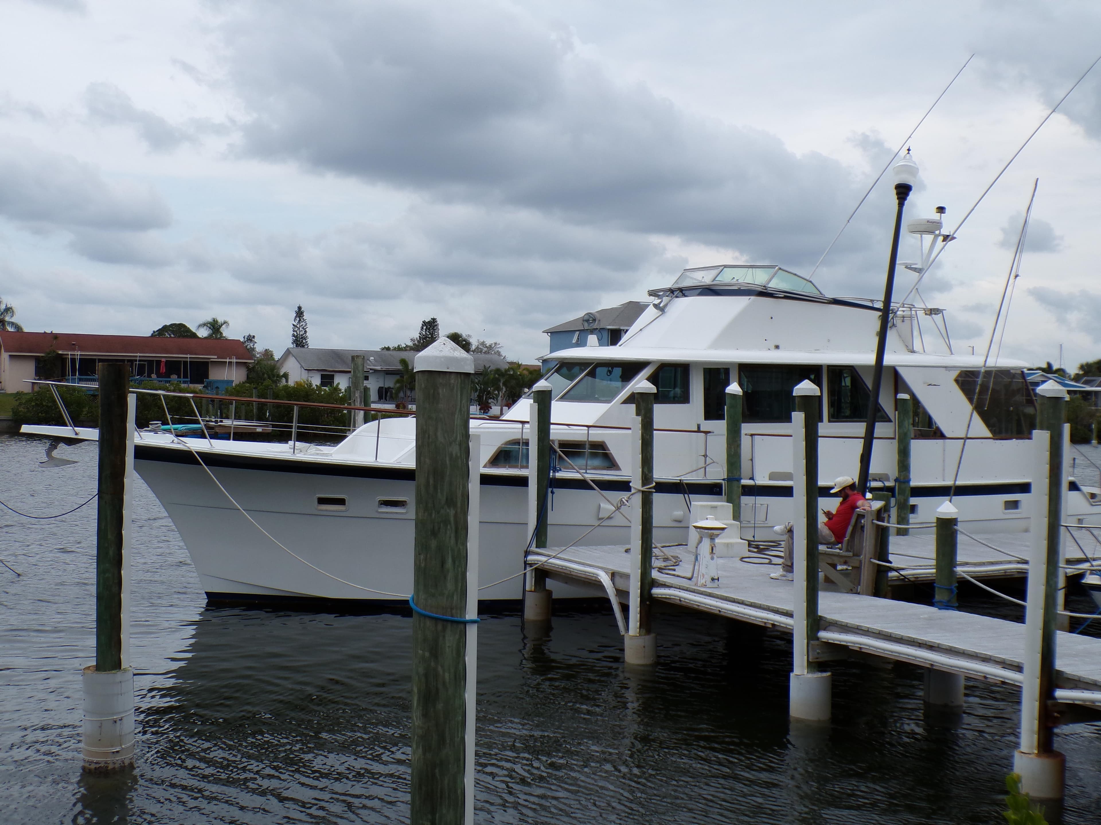1978 Hatteras 58 Yacht Fisherman docked at a marina under cloudy skies.