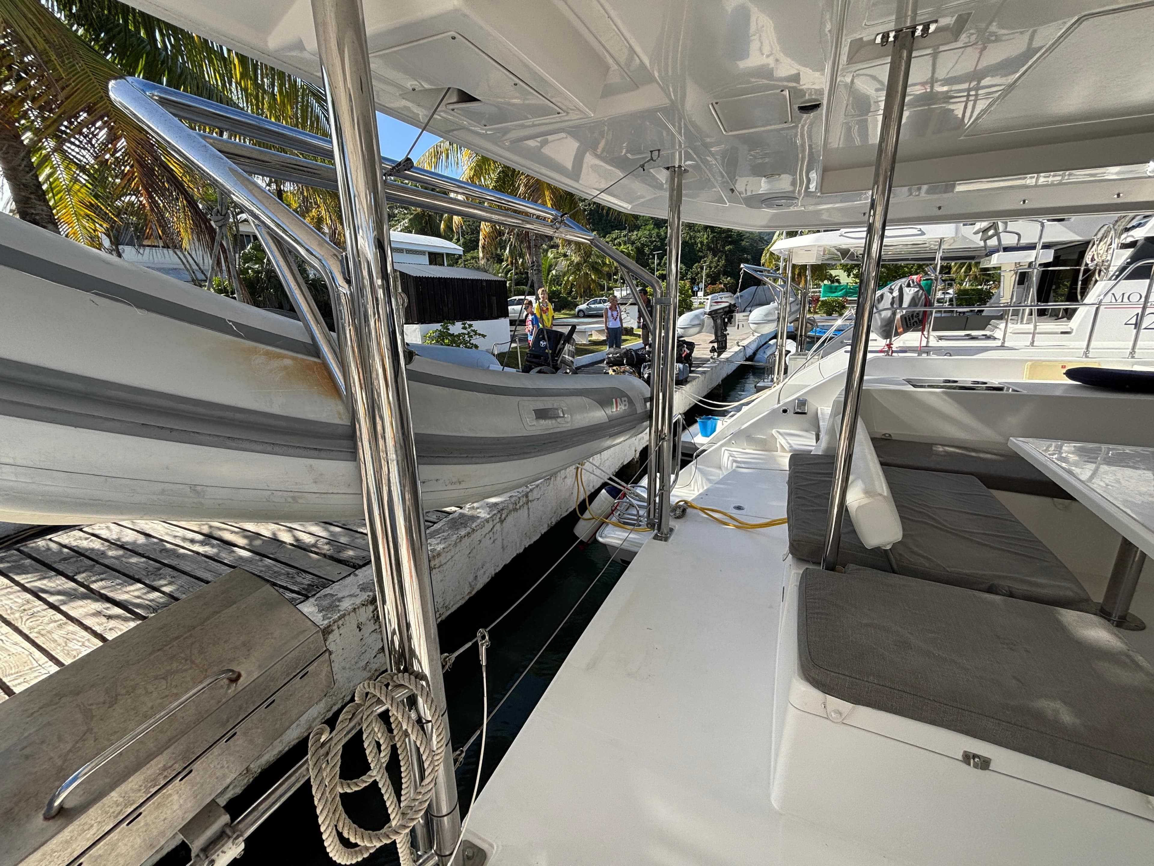 2019 Leopard 40 catamaran with dinghy, docked in a tropical marina setting.