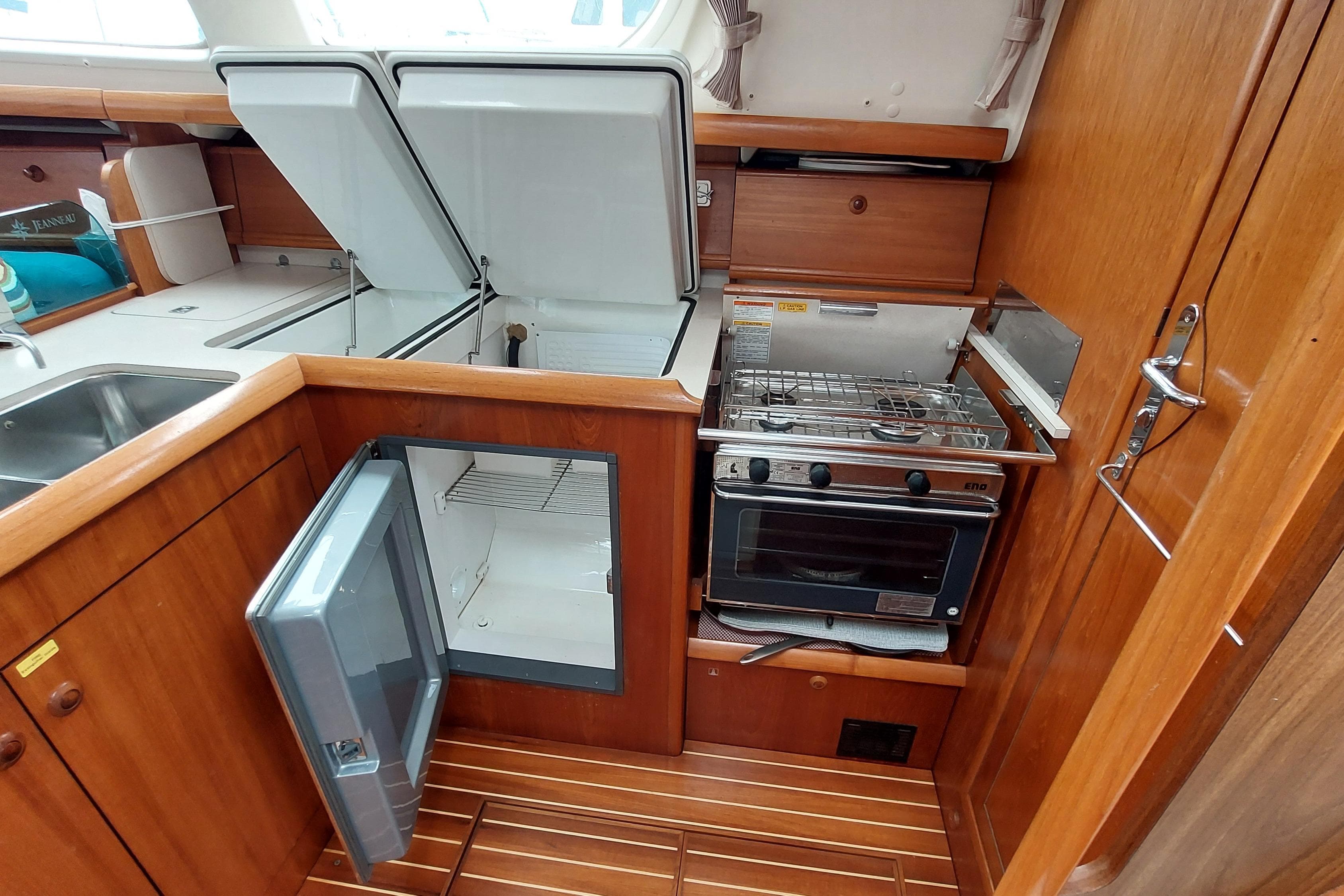 Kitchen area of 2002 Jeanneau Sun Odyssey 43 DS yacht with stove, fridge, and sink.