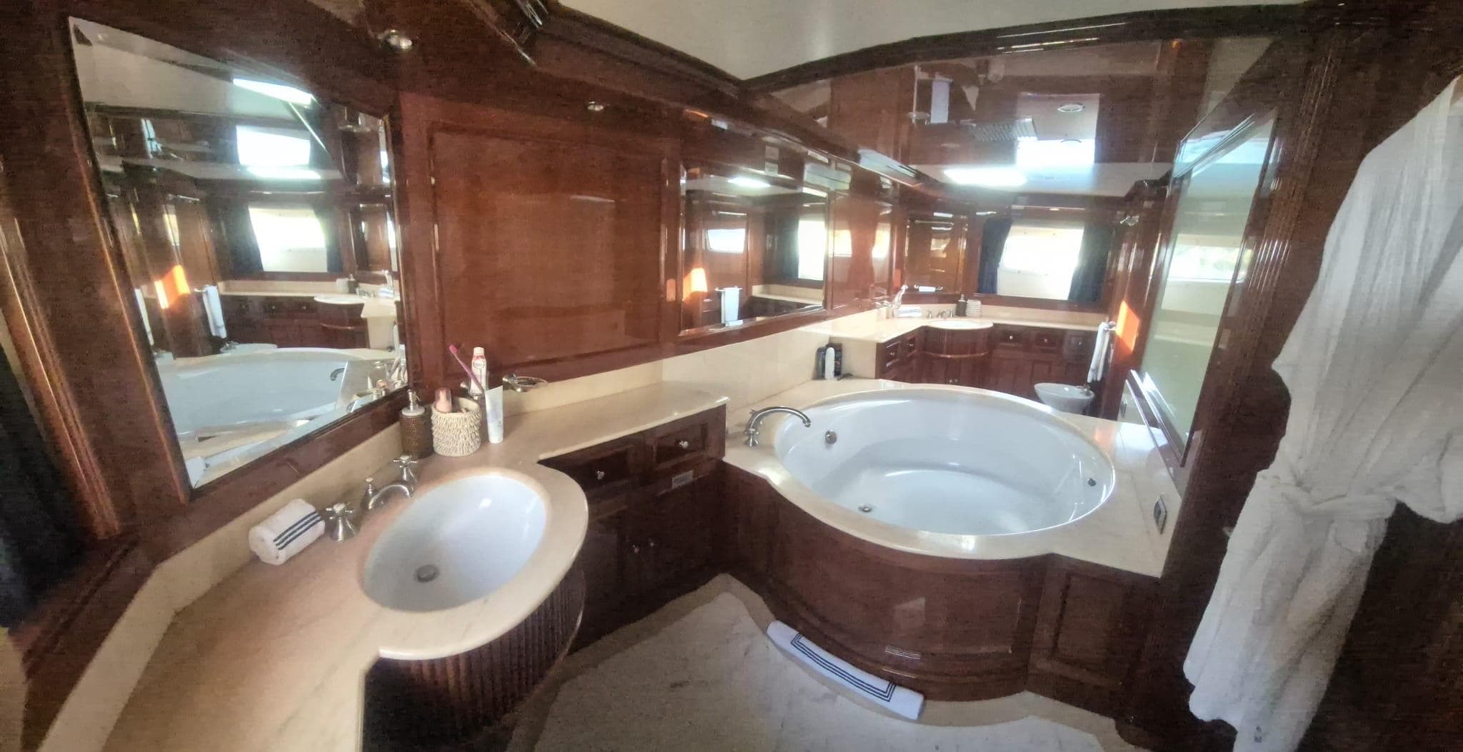 Luxurious bathroom on 2000 Benetti Classic 115 yacht with wood accents and jacuzzi tub.