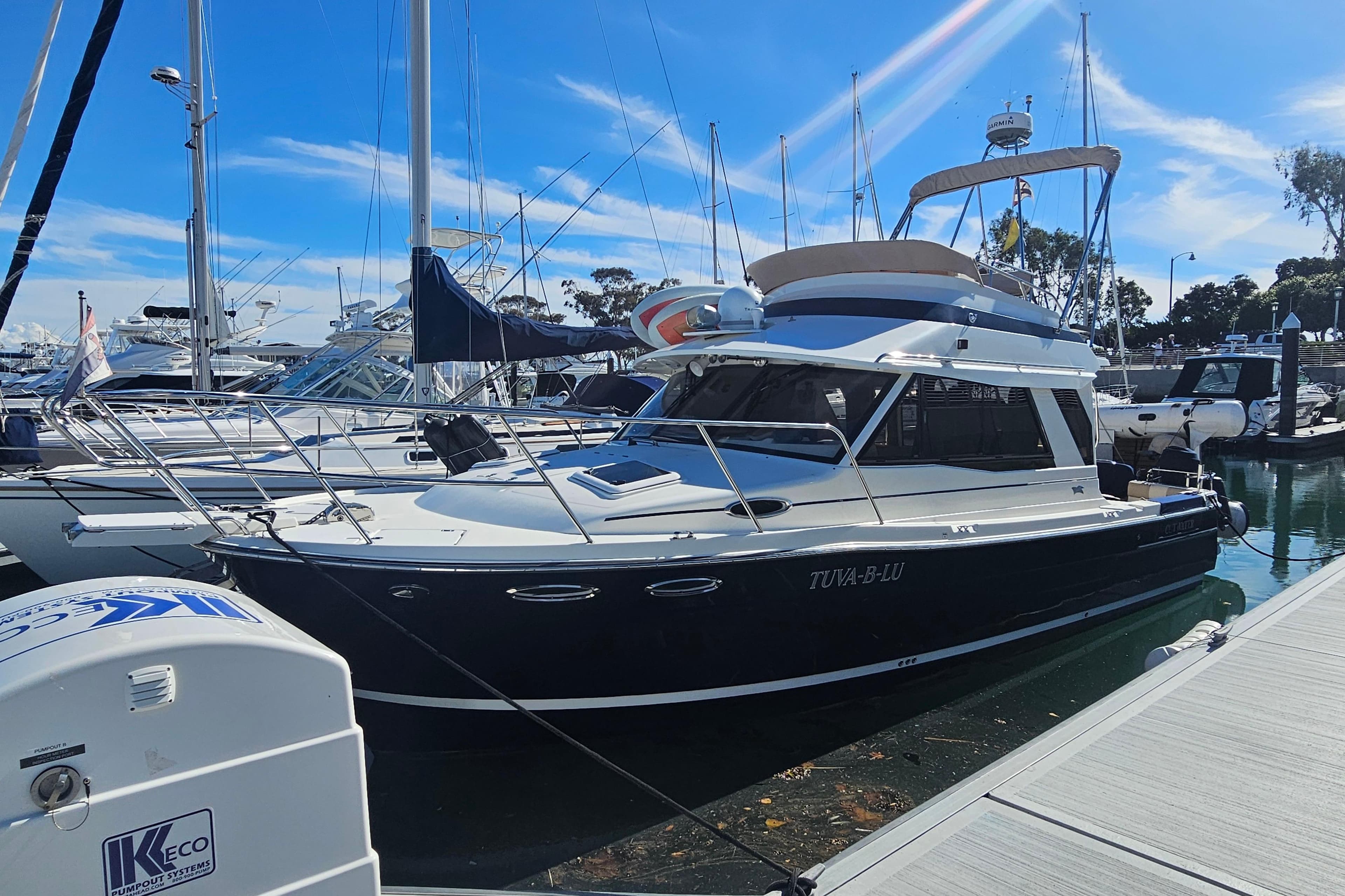 2015 Cutwater 30 Command Bridge yacht docked at marina under clear blue sky.