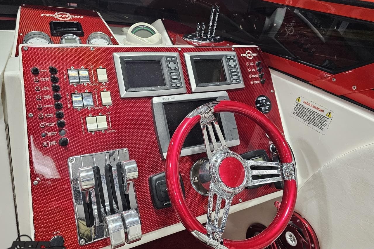 Dashboard of a 2009 Fountain 47 Lightning boat with red accents and navigation controls.