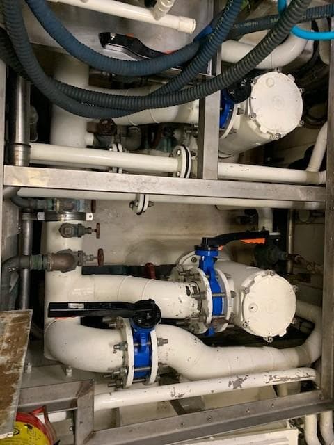 Engine room of 2010 Benetti Tradition 100 yacht with visible pipes and valves.