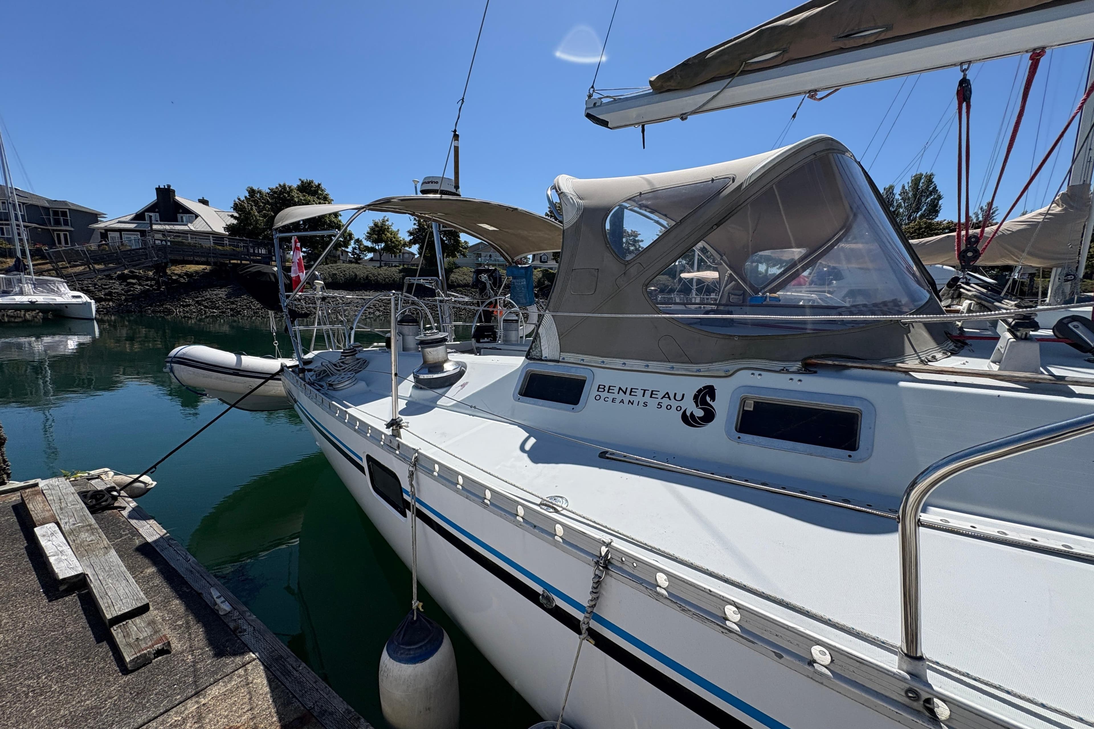 1990 Beneteau Oceanis 500 yacht docked in a marina under clear blue skies.