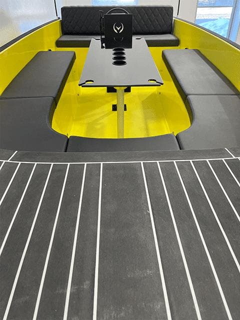 2023 Vision Marine Technologies Volt 180 boat interior with yellow seating and black table.