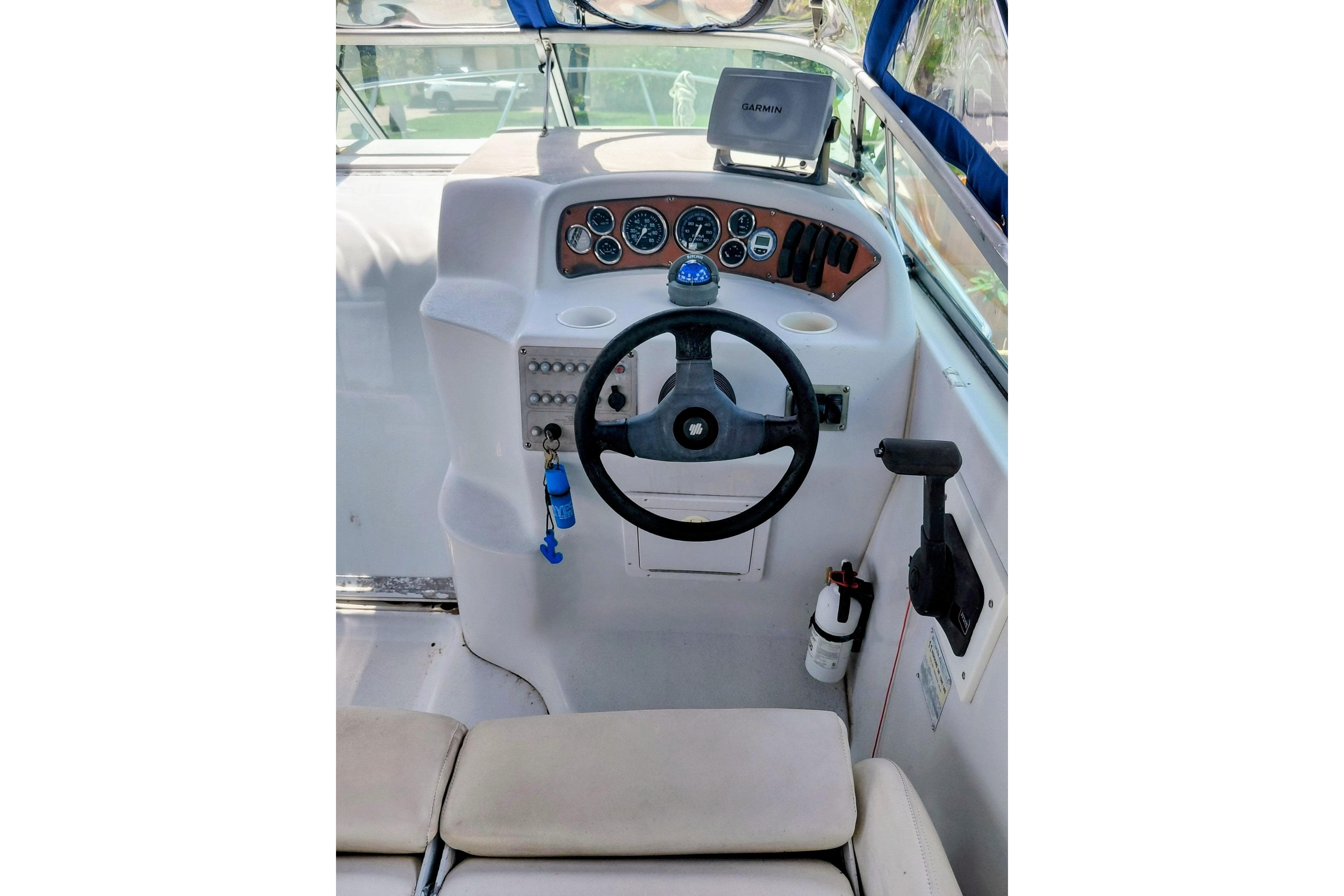 Cockpit of 2000 Crownline 242 CR boat with steering wheel and navigation equipment.